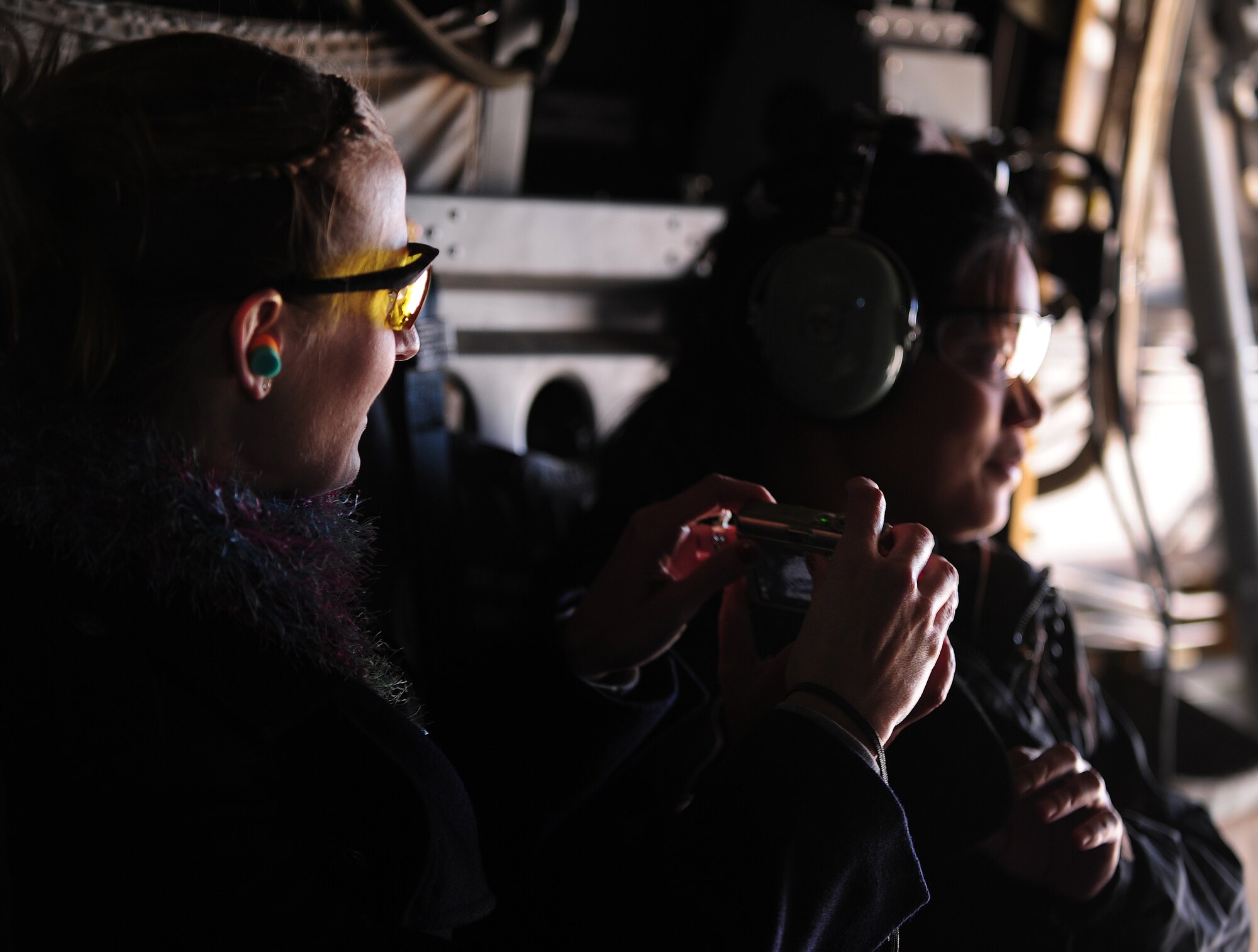 The spouse of a U.S. Air Force member stationed at Cannon Air Force Base, N.M., Oct 27, 2012, takes a picture while aboard a CV-22 Osprey. Husbands and wives are welcomed to the base and given the chance to ride in a military aircraft during annual Spouse Orientation Flights. (U.S. Air Force photo/Airman 1st Class Ericka Engblom)