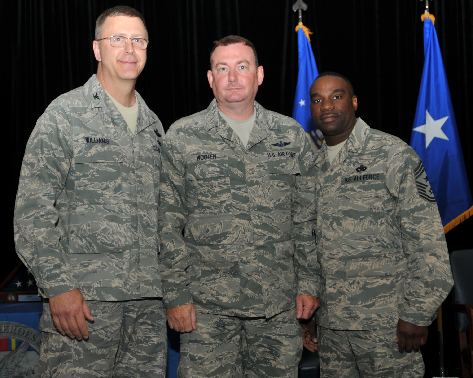 Senior Master Sgt. Donnie Wooten, a member of the 156th Aeromedical Evacuation Squadron, receives recognition and appreciation from Colonel Roger E. Williams, Jr., 145th Airlift Wing Commander and Command Chief Master Sergeant Maurice Williams during an official Air National Guard ceremony known as the Hometown Heroes Salute.  Each airman who served 30 or more days away from home throughout operations Iraqi Freedom, Enduring Freedom and New Dawn is awarded a framed Hometown Heroes Salute Coin with a Letter of Appreciation signed by the ANG Director and Command Chief Master Sergeant, and a Pen & Pencil Set for their spouse or significant other. (National Guard photo by Tech. Sgt Brian Christiansen, 145th Public Affairs)