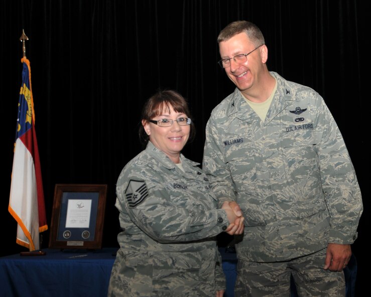 Master Sgt. Christy Bensley, a member of the 145th Logistics Readiness Squadron, receives recognition and appreciation from Colonel Roger E. Williams, Jr., 145th Airlift Wing Commander during an official Air National Guard ceremony known as the Hometown Heroes Salute.  Each airman who served 30 or more days away from home throughout operations Iraqi Freedom, Enduring Freedom and New Dawn is awarded a framed Hometown Heroes Salute Coin with a Letter of Appreciation signed by the ANG Director and Command Chief Master Sergeant, and a Pen & Pencil Set for their spouse or significant other. (National Guard photo by Tech. Sgt Brian Christiansen, 145th Public Affairs)