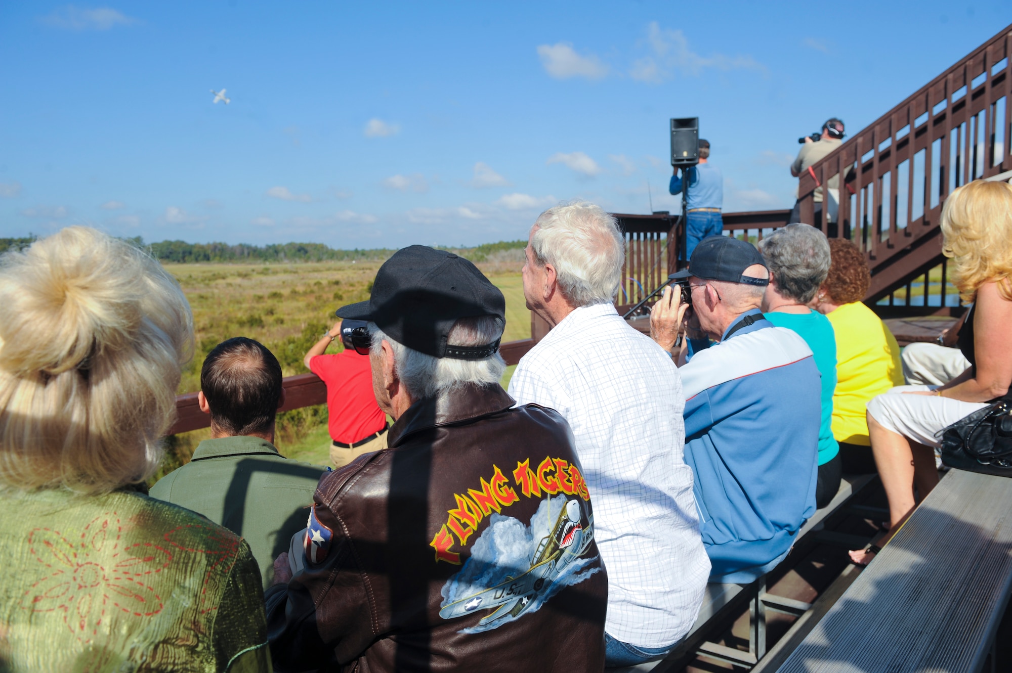 Members of the 2012 Flying Tigers Reunion watch an A-10C Thunderbolt II aircraft fly over during a training demonstration at Moody Air Force Base, Ga., Oct. 25, 2012. Throughout the demonstration, Capt. Slop Gibson, 75th Fighter Squadron director of staff, explained the action each aircraft performed. (U.S. Air Force photo by Airman 1st Class Olivia Bumpers/Released)
