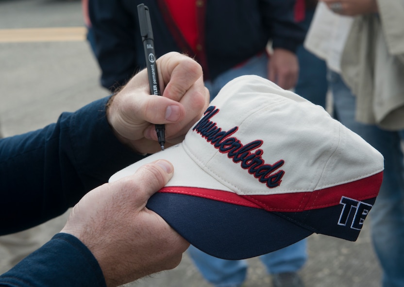 A member of the U.S. Air Force Air Thunderbirds Flight Demonstration Team signs a hat during the Moody Air Force Base, Ga., Legacy of Liberty Open House air show Oct. 27, 2012. After the hats were signed, they were given to the family of fallen warrior U.S. Air Force Senior Airman Michael J. Buras, who was killed in Kandahar, Afghanistan, by an improvised explosive device on Sept. 21, 2010.. (U.S. Air Force photo by Senior Airman Douglas Ellis/Released) 

