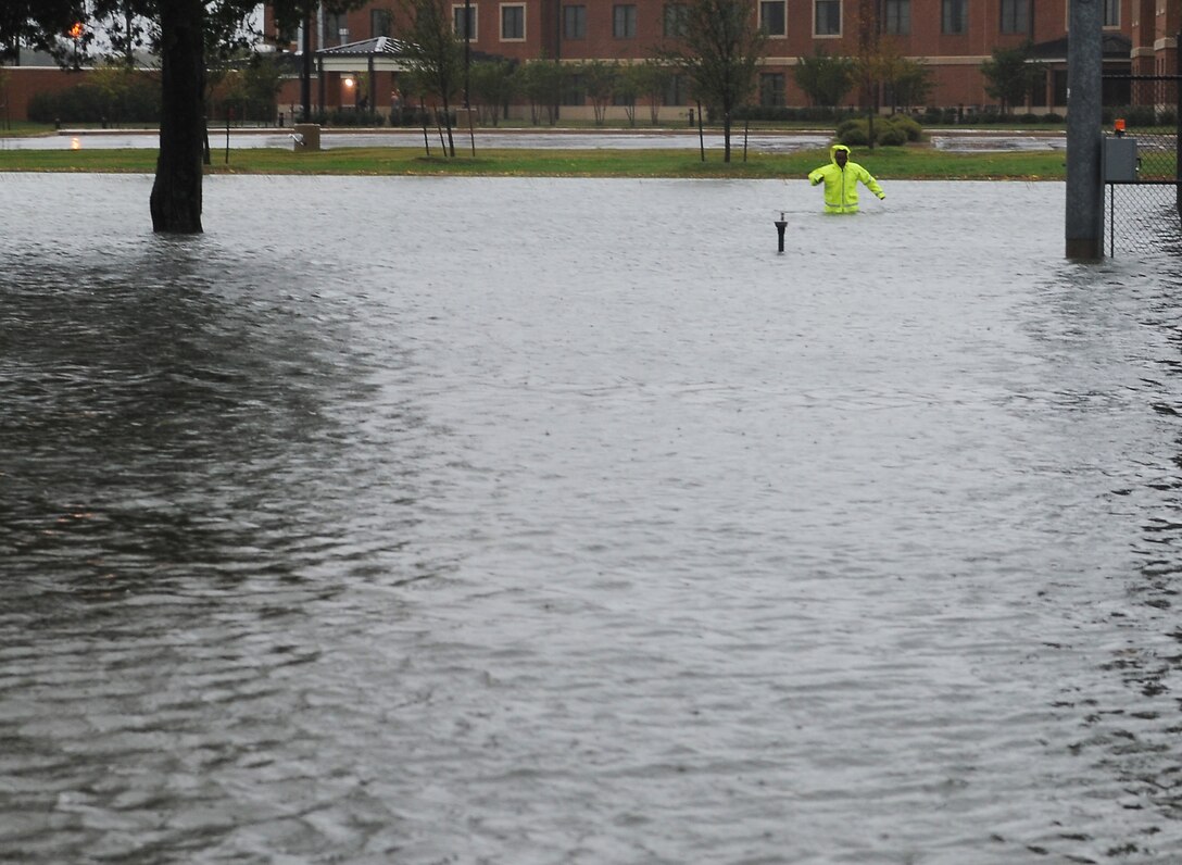 U.S. Air Force Airman Nahom Tumalisan, 633rd Civil Engineer Squadron electrical systems technician, wades through water while checking electrical systems during Hurricane Sandy at Langley Air Force Base, Va., Oct. 29, 2012. Joint Base Langley-Eustis implemented base closures and infrastructure protection measures to mitigate storm damage at Langley AFB and Fort Eustis. (U.S. Air Force photo by Airman 1st Class Teresa Aber/Released)