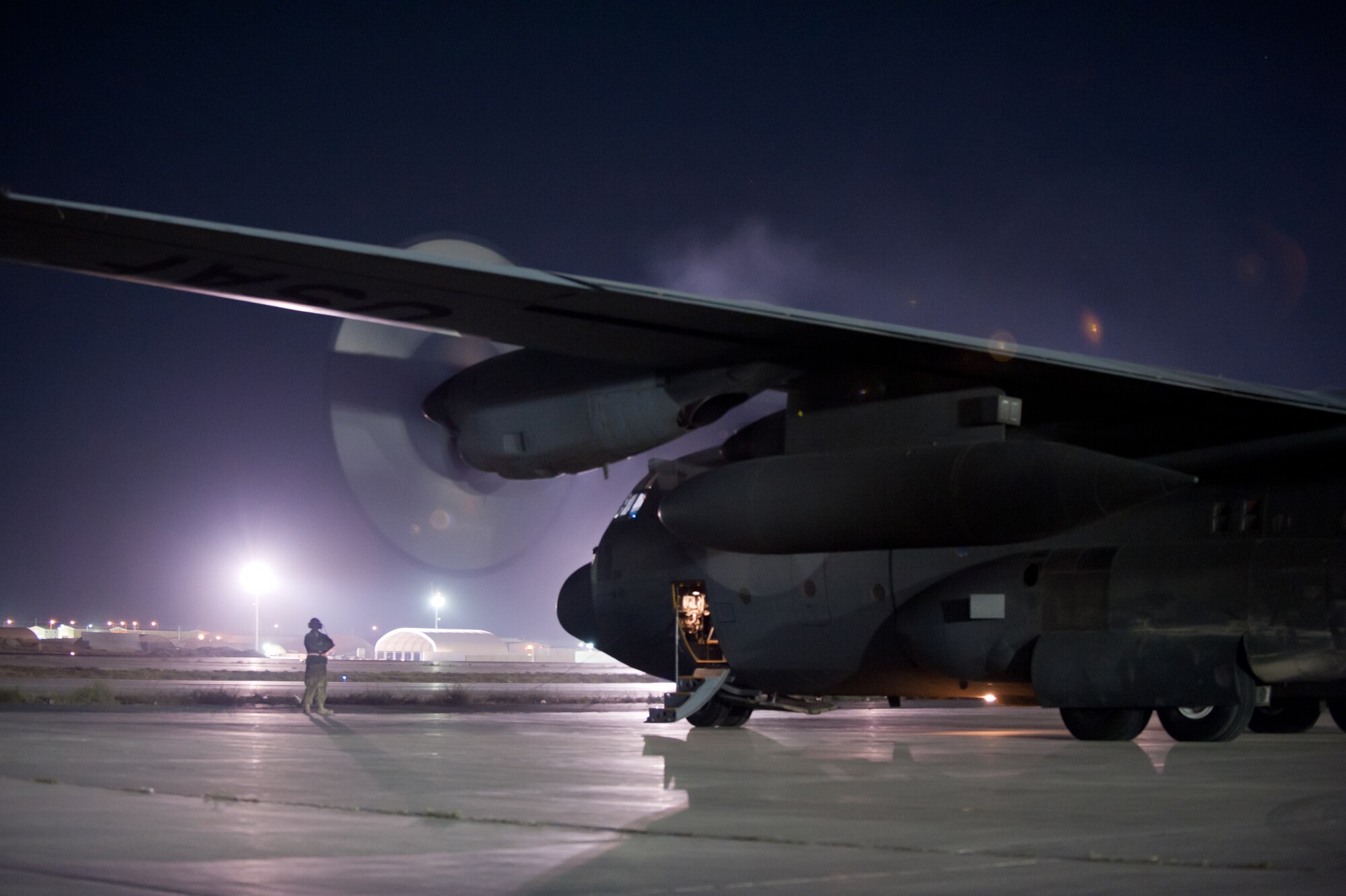 An aircraft maintainer assigned to the 455th Expeditionary Aircraft Maintenance Squadron prepares to marshal a U.S. Air Force C-130H Hercules prior to a night mission at Bagram Airfield, Afghanistan, Oct. 25, 2012. The C-130H is a tactical airlift workhorse for American and coalition forces in Afghanistan. (U.S. Air Force Photo/Staff Sgt. Jeff Nevison)