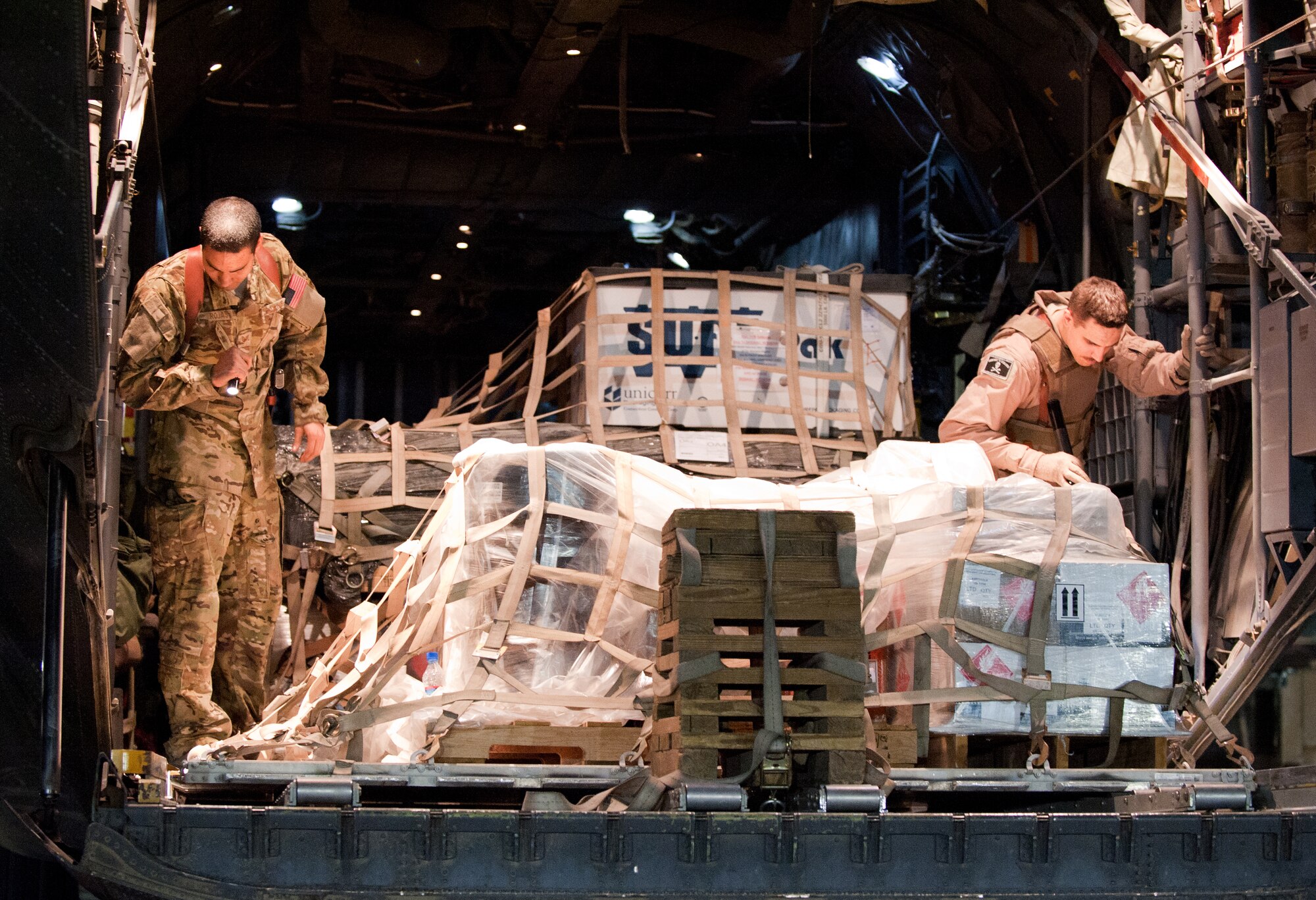 Staff Sgt. Steven Rojas from Riverside, Calif. (left), and Airman 1st Class Emilio Santos from Syracuse, NY, 774th Expeditionary Airlift Squadron loadmasters, ensure cargo pallets are locked into a C-130H Hercules prior to a night mission at Bagram Airfield, Afghanistan, Oct. 25, 2012. The C-130H is a tactical airlift workhorse for American and coalition forces in Afghanistan. (U.S. Air Force Photo/Staff Sgt. Jeff Nevison)