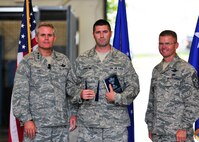 Master Sgt. Thomas Webster of the 919th Operations Group Detachment 2, center, clutches two major awards presented to him recently by Lt. Gen. Eric Fiel, the commander of Air Force Special Operations Command, left, and Chief Master Sgt. William Turner, AFSOC's command chief, at Duke Field, Fla.  Webster was named the 2011 Outstanding Air Force Reserve Component Intelligence, Surveillance and Reconnaissance Senior NCO and 2011 Outstanding Air Force ISR Senior NCO. (U.S. Air Force photo/Tech. Sgt. Cheryl Foster)