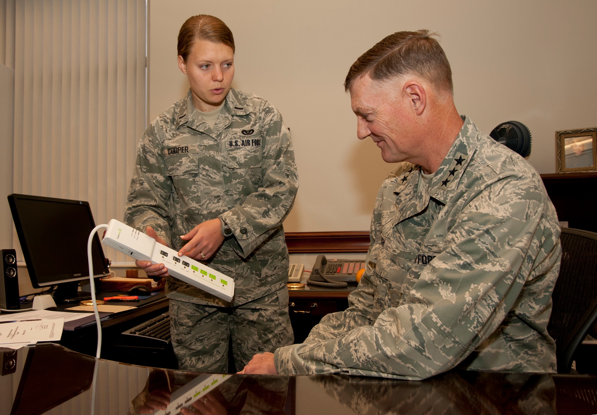 1st Lt. Rachael Cooper (left), facility energy program manager, Air Force Materiel Command, explains capabilities of new smart power strip to Lt. Gen. Andrew Busch, vice commander, AFMC, on Oct. 12. (Photo by Michelle Gigante) 
