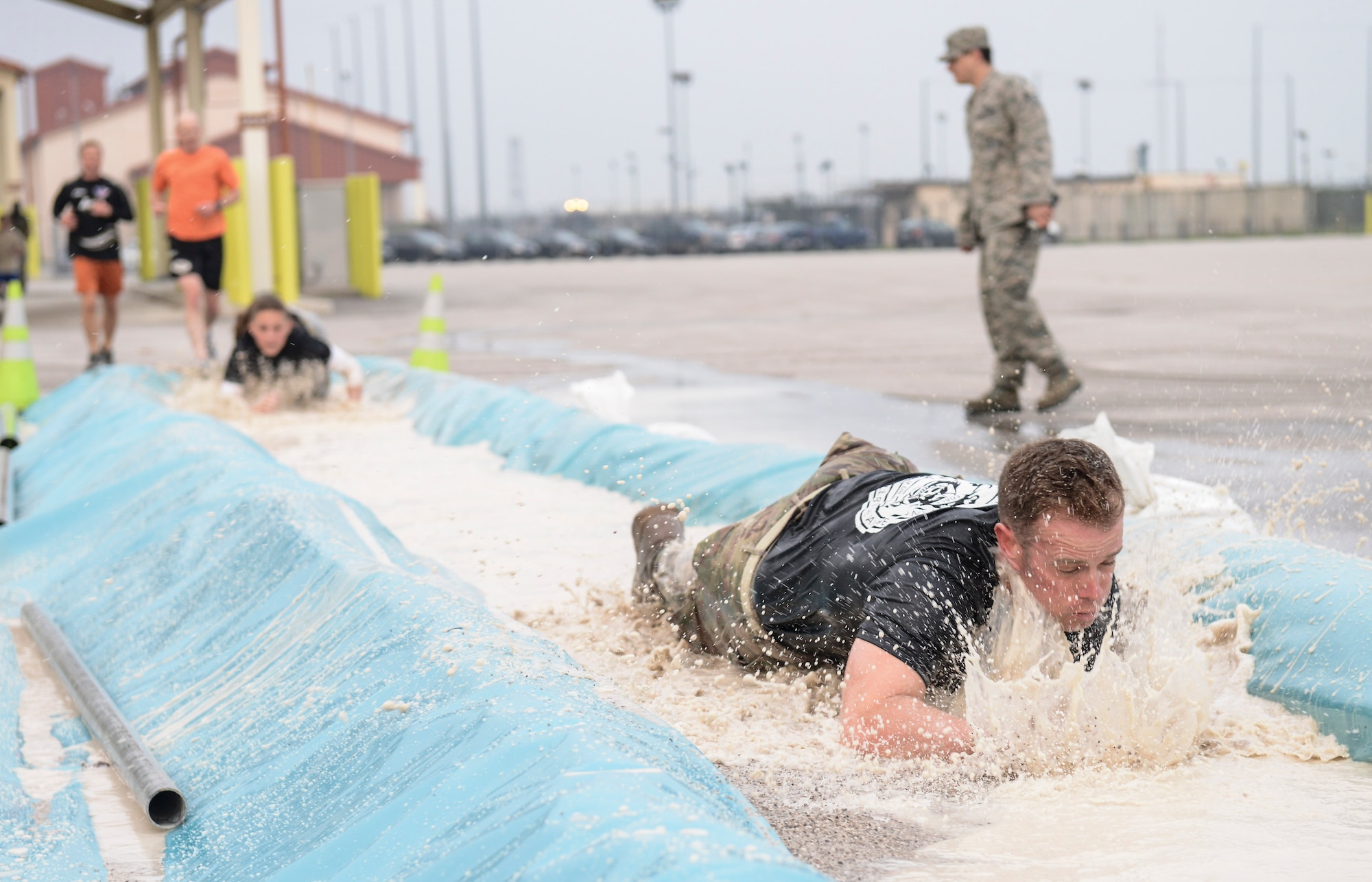 Participants low crawl through water during the 2nd Annual Israel Del Toro Combat Run held Oct. 26 at Aviano Air Base, Italy. More than 200 people participated in the race, which included a wall jump, balance beam, low crawl course, sandbag carry and several other obstacles on the 5-kilometer course. (U.S. Air Force photo by Senior Airman Katherine Tereyama)