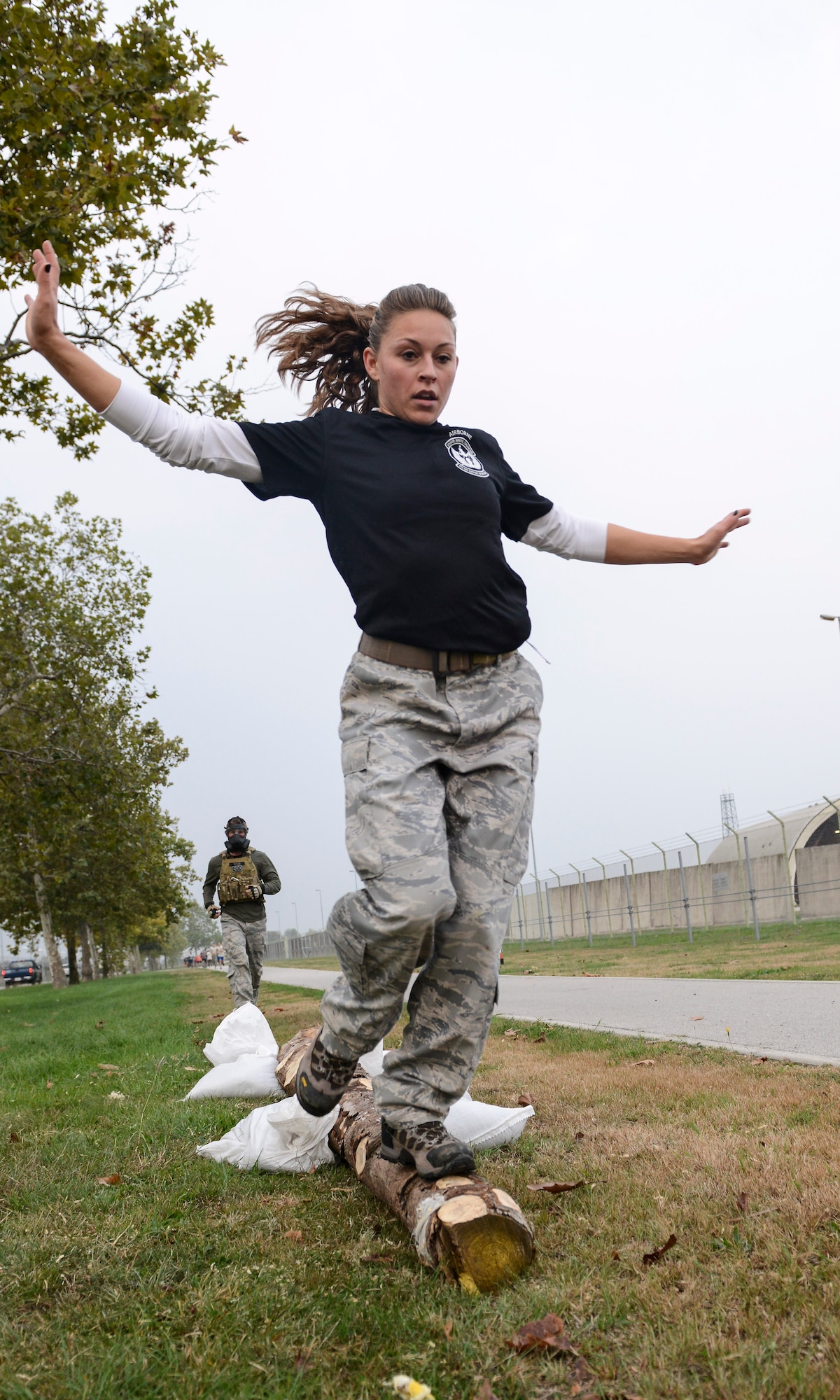Megan Tandberg, wife of Capt. Paul Tandberg, 8th Air Support Operations Squadron, runs across a balance beam during the 2nd Annual Tech. Sgt. Israel Del Toro Combat Run held Oct. 26 at Aviano Air Base, Italy. More than 200 people ran the race held in honor of wounded warriors, including the Tandbergs who came from Vicenza, Italy to participate. (U.S. Air Force photo by Senior Airman Katherine Tereyama)