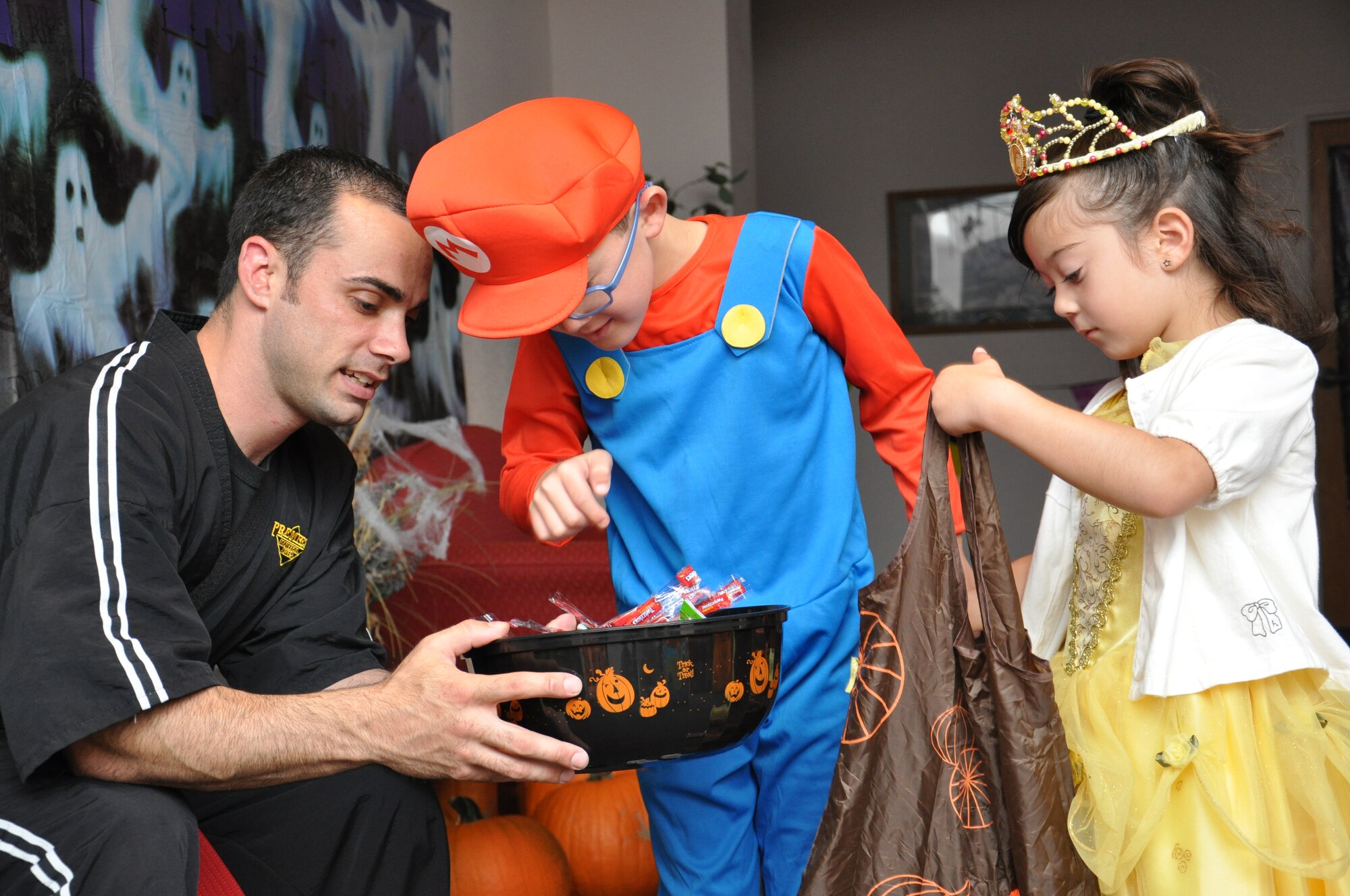 Riku and Emma York pick candy out of a bowl Oct. 26 during the Special Needs Halloween Bash held at the Airman and Family Readiness Center. Several stations were set up for the children including trick or treating, a small movie theater, arts and crafts and a hay ride. (U.S. Air Force photo/Staff Sgt. Timothy Boyer)