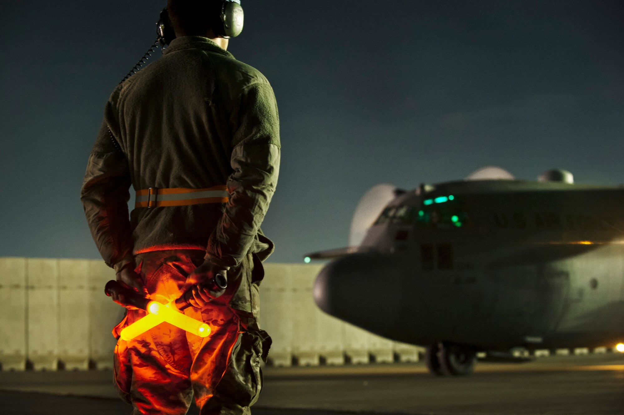 A maintainer assigned to the 455 Expeditionary Aircraft Maintenance Squadron stands ready to taxi a C-130H Hercules out of its parking space prior to a night mission at Bagram Airfield, Afghanistan, Oct. 25, 2012. Bagram provides dedicated tactical airlift support to ground forces operating in Afghanistan. (U.S. Air Force photo/Capt. Raymond Geoffroy)