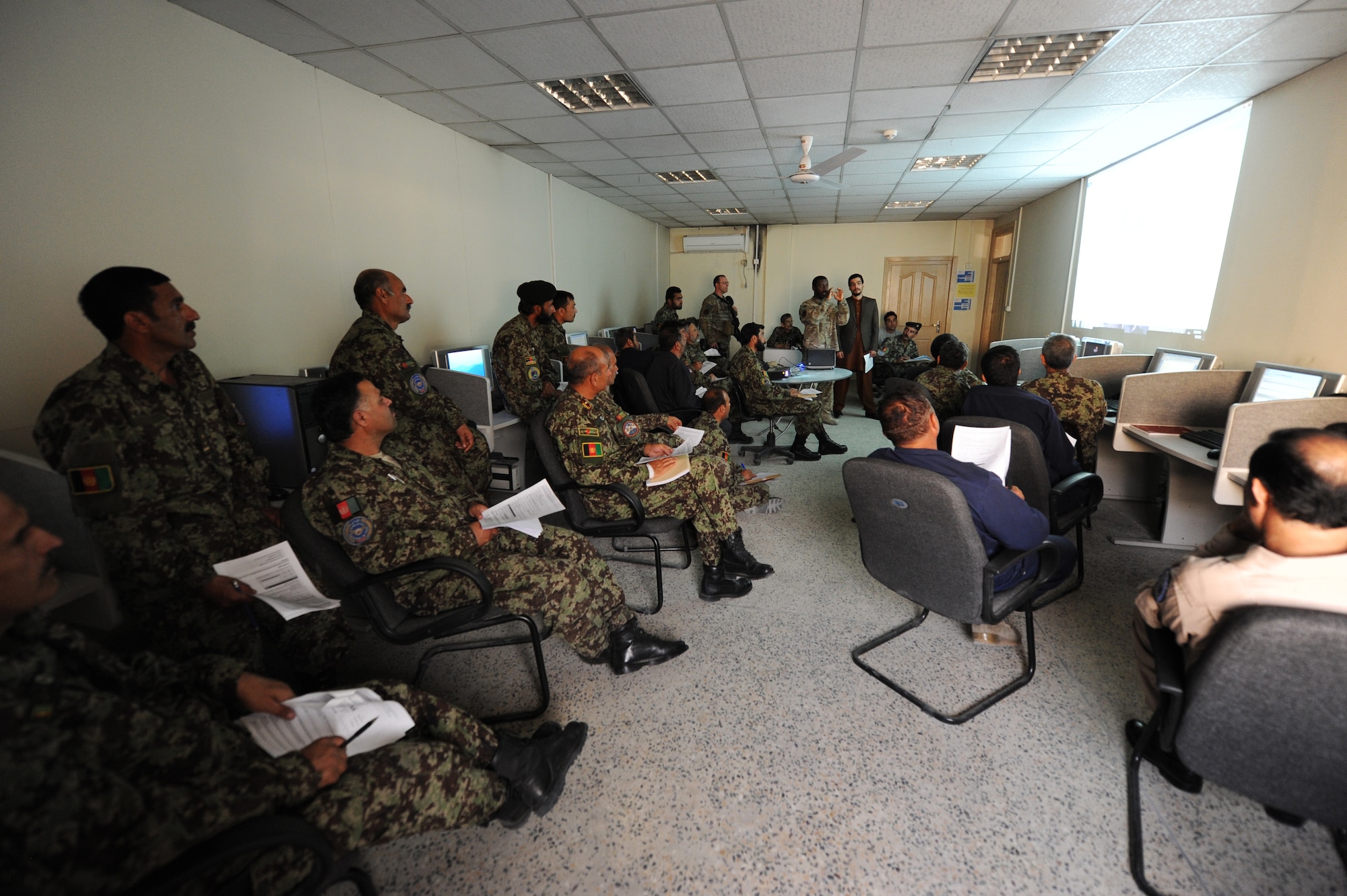Afghan Air Force students look on as Master Sgt. Fred Anane, 438th Air Expeditionary Advisory Group Plans and Scheduling Advisor teaches the class about charts and graphs in the Microsoft Excel program at the Kabul, Afghanistan, International Airport. Anane, with the help of Master Sgt. Mark Jansen, 438th AEAG Quality Assurance advisor, developed computer classes for AAF schedulers, mission operations control center personnel and analyst soldiers.(Air Force photo by Staff Sgt. Melissa K. Mekpongsatorn) 
