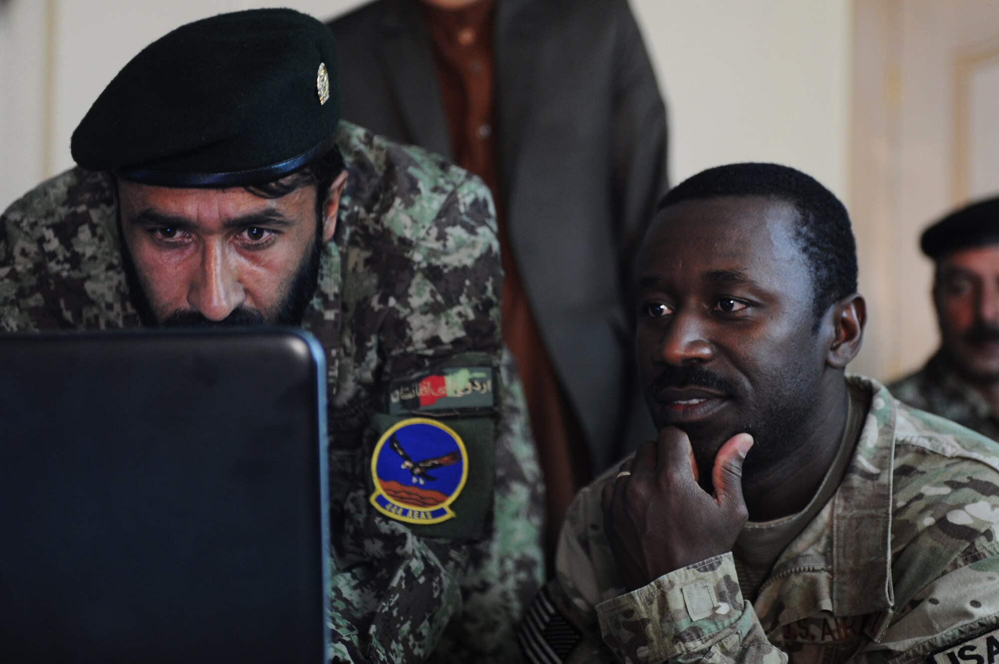 U.S. Air Force Master Sgt. Fred Anane, 438th Air Expeditionary Advisory Group Plans and Scheduling advisor, assists Afghan Air Force Lt. Abdul Ghafer during computer class at the Kabul, Afghanistan, International Airport. Anane, with the help of Master Sgt. Mark Jansen, 438th AEAG Quality Assurance advisor, developed computer classes for AAF schedulers, mission operations control center personnel and analyst soldiers.(Air Force photo by Staff Sgt. Melissa K. Mekpongsatorn) 
