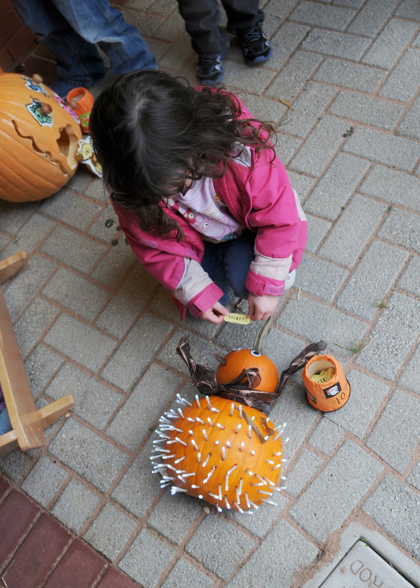 Myra Tiamzon, 3, daughter of Staff Sgt. Edwardson Tiamzon, 100th Logistics Readiness Squadron unit deployment manager, votes her favorite decorated pumpkin during the Child Development Center Fall Festival Oct. 26, 2012, at RAF Mildenhall, England.  Child care providers from the CDC decorated pumpkins for the festival and the children voted their favorites.  (U.S. Air Force photos by Staff Sgt. Tabitha M. Lee/Released)