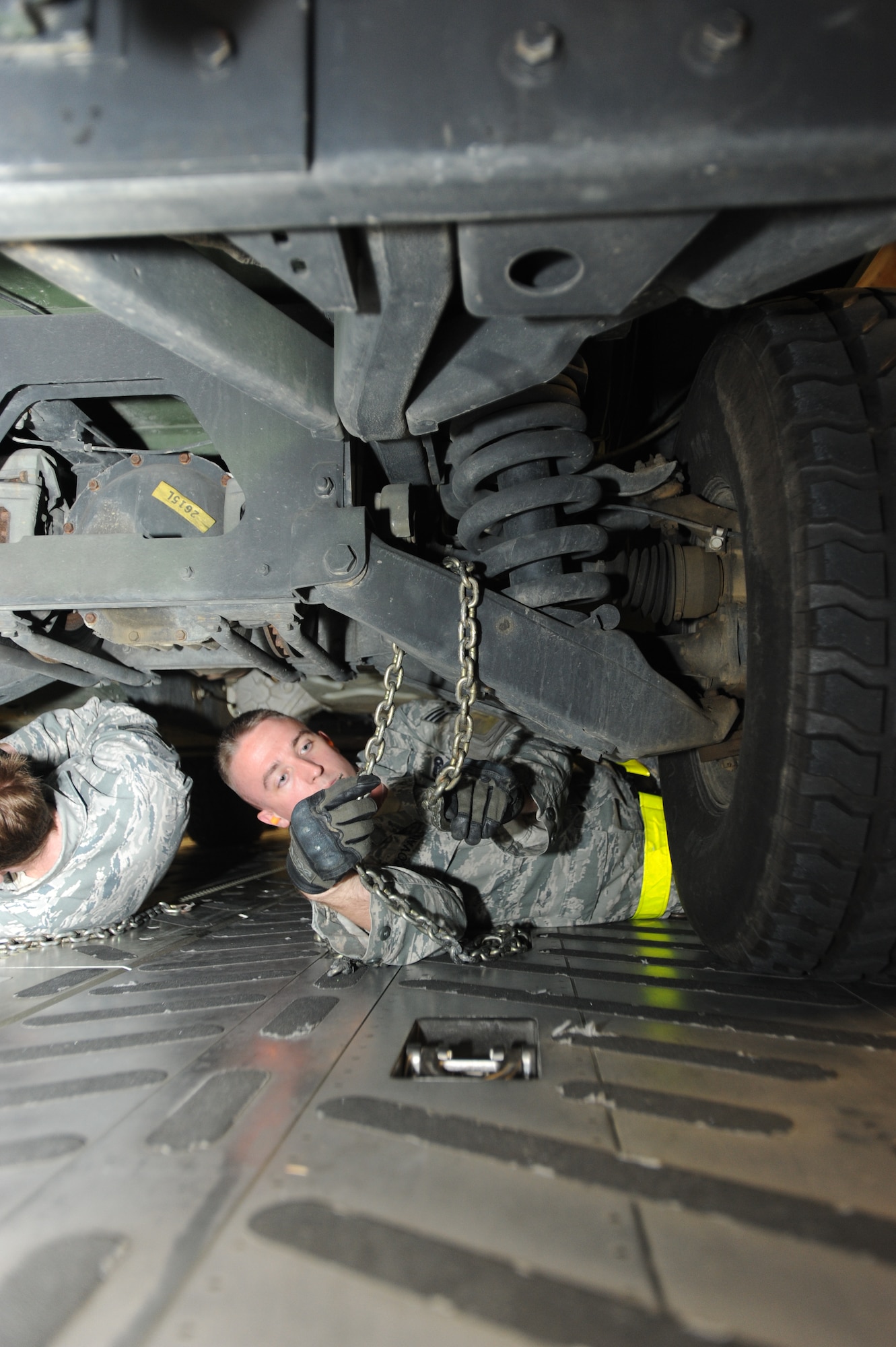 JOINT BASE MCGUIRE-DIX-LAKEHURST-- Senior Airman Matthew Covault, 305th Aerial Port Squadron apex driver, secures a Humvee for transport in a C-17 Globemaster III bay Oct. 27, 2012, here. The 621st Contigency Response Wing is moving their equipment to avoid possible damage from approaching Hurricane Sandy. (U.S. Air Force photo by Airman Sean Crowe/ Released

