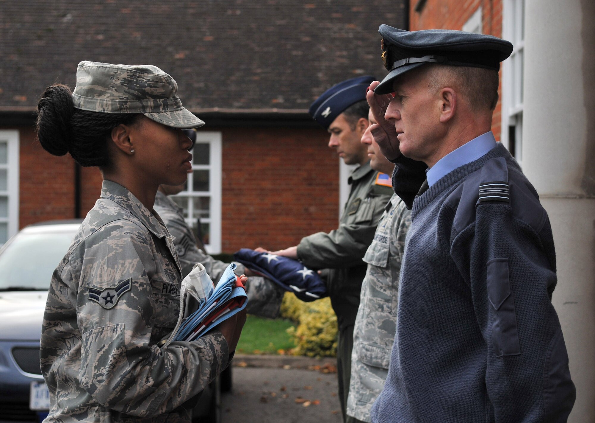 Squadron Leader Rick Fryer salutes as he receives the British Flag following a retreat ceremony Oct. 26, 2012, on RAF Mildenhall, England. The monthly retreat ceremony was hosted by the 352nd Special Operations Group. (U.S. Air Force photo by Senior Airman Jerilyn Quintanilla/Released) 