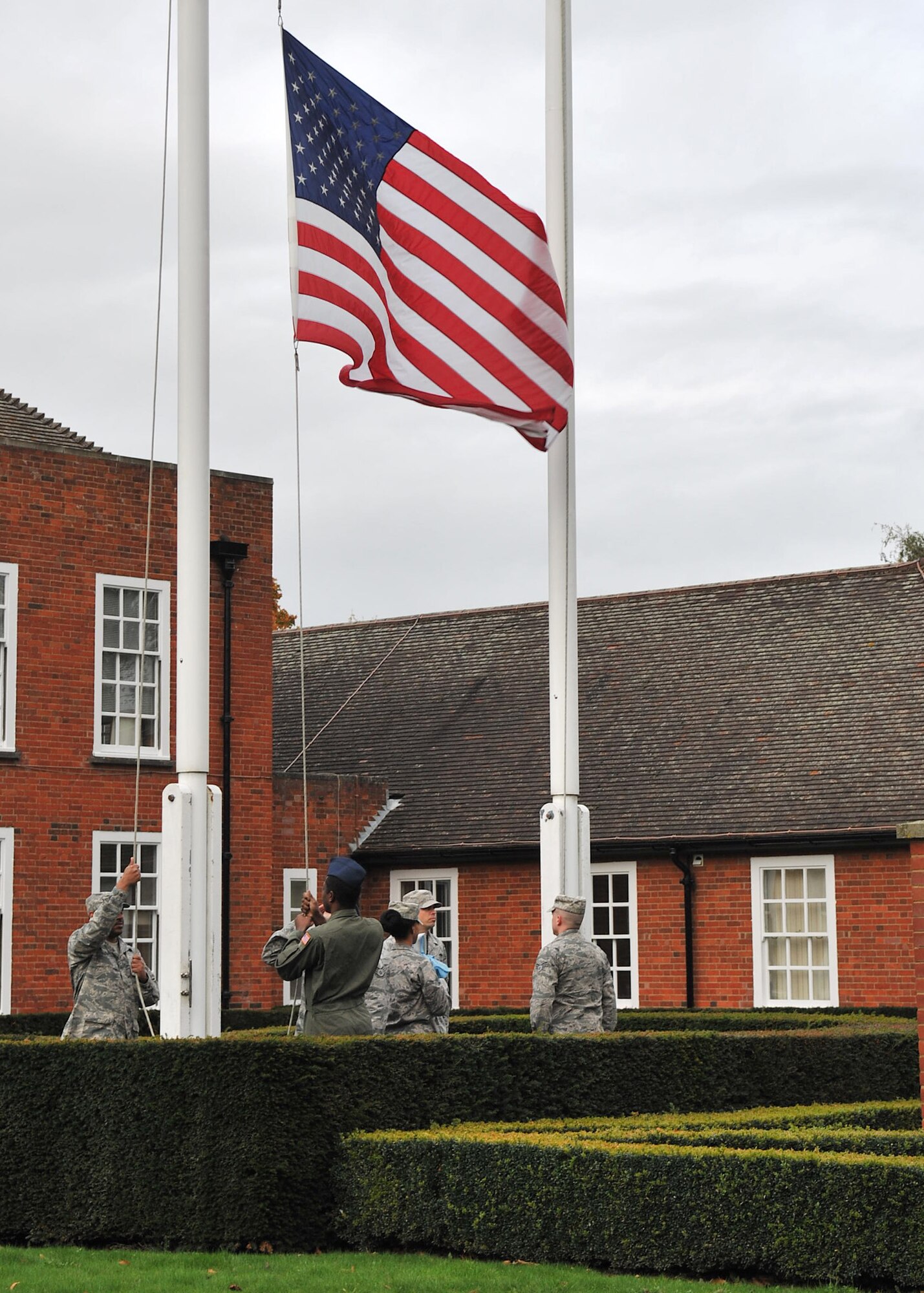 Airmen from the 352nd Special Operations Group lower the flag during a retreat ceremony Oct. 26, 2012, on RAF Mildenhall, England. Retreat pays respect to the American and British flags as well as signifies the end of the duty day. (U.S. Air Force photo by Senior Airman Jerilyn Quintanilla/Released)