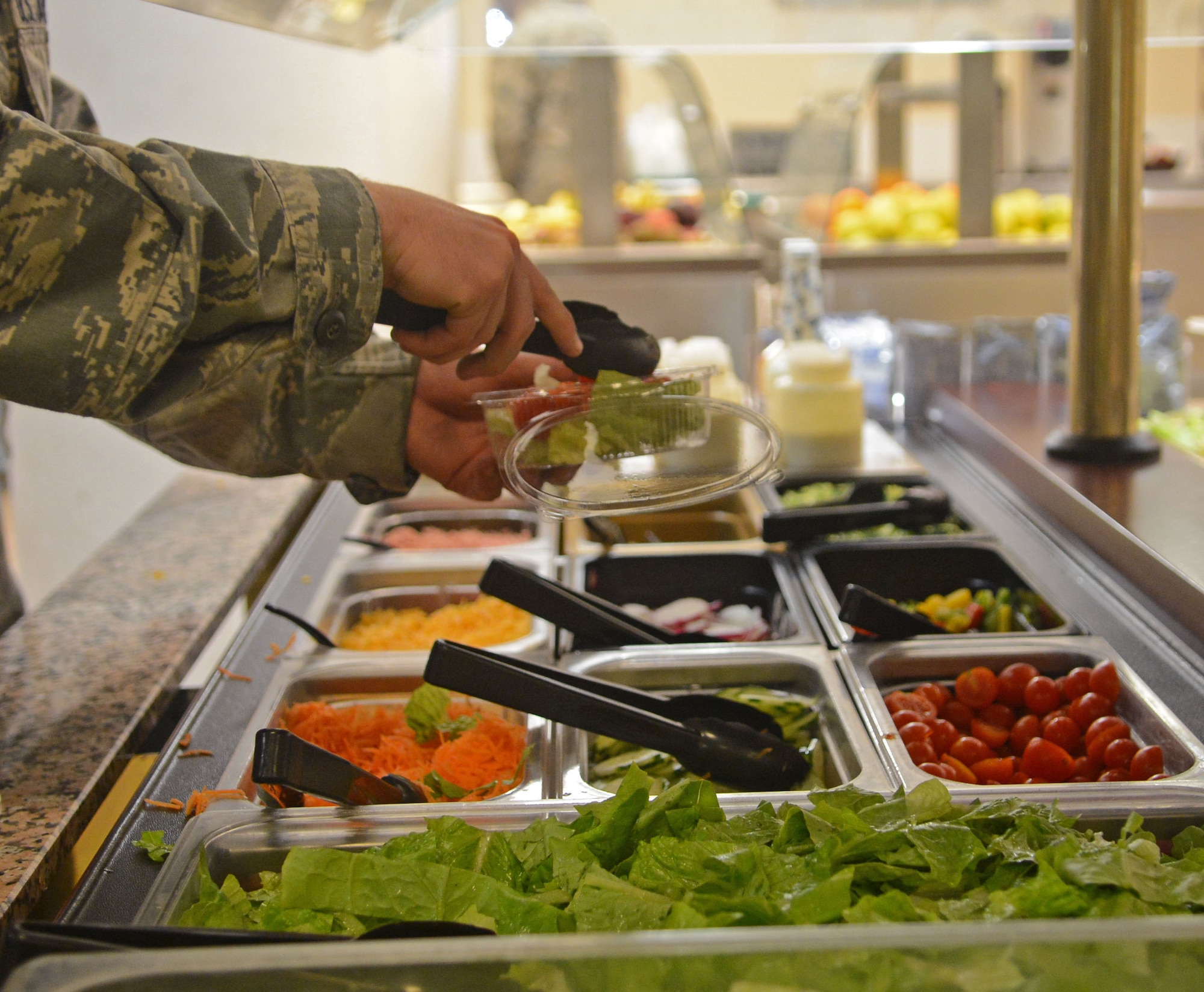 An Airman prepares a salad at the La Dolce Vita Dining Facility at Aviano Air Base, Italy, Oct. 24. "Go for Green" is a new color-coded system that shows Airmen the calorie count intake of each item on the menu and what foods should be consumed less often than others. (U.S. Air Force photo/Airman 1st Class Matthew Lotz)