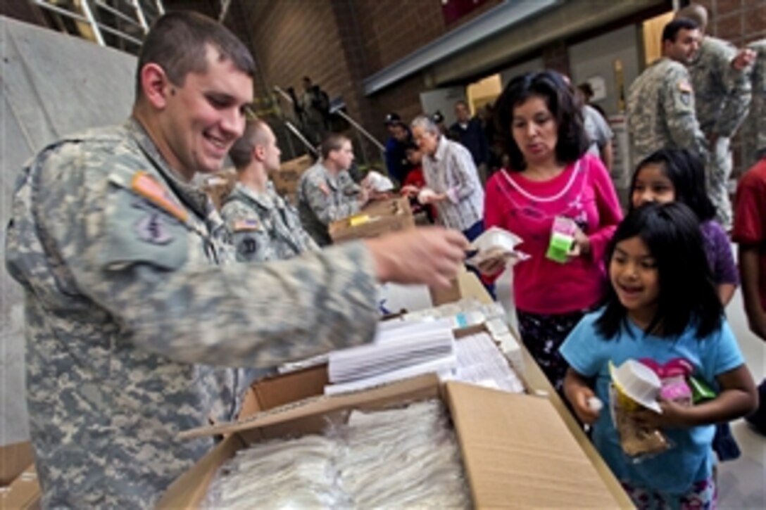 Army Sgt. Michael Ryno provides assistance to a family displaced by Hurricane Sandy at an emergency shelter at the Werblin Recreation Center in Piscataway Township, N.J., Oct. 29, 2012. Ryno and fellow soldiers are assigned to the 50th Infantry Brigade Combat Team, New Jersey Army National Guard.