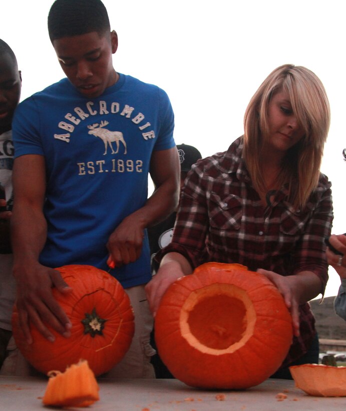 Marines with 1st Supply Battalion, Combat Logistics Regiment 15, 1st Marine Logistics Group, carve pumpkins during the 1st Supply Bn. Barracks Bash at Camp Pendleton, Calif., Oct. 25. The celebration included a pumpkin launching contest, pie-eating contest, and a pork shoulder cooking contest.