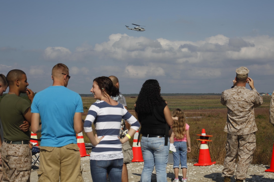 Families watch an AH-1W Cobra fly out to strike targets on a bombing range at Marine Corps Base Camp Lejeune, N.C., Oct. 19. Marine Light Attack Helicopter Squadron 467 held a family day and live fire demonstrations to help families understand what their Marines do for a living.