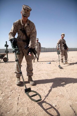 U.S. Navy Hospital Corpsman 3rd Class, foreground, Headquarters Company, Regimental Combat Team 7, practices using a metal detector during the practical application portion of an improvised explosive device (IED) detection class at Camp Leatherneck, Helmand province, Afghanistan, Oct. 15, 2012. The class was part of counter IED training which familiarized the Marines with fundamentals to include: unexploded ordnance recognition, enemy tactics, homemade explosives, threat detection, ground signs awareness, and downed vehicle procedures. (U.S. Marine Corps photo by Cpl. Alejandro Pena/Released)