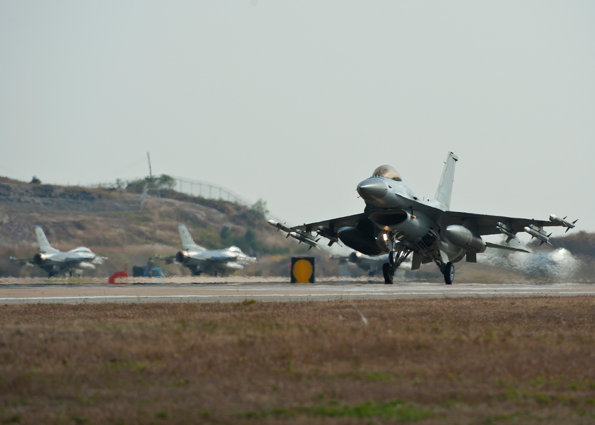 An F-16 Fighting Falcon with the 38th Fighter Group lands while other F-16s wait to takeoff during exercise Max Thunder 12-2 on Kunsan Air Base, Republic of Korea, Oct. 29, 2012. Max Thunder is a chance for U.S. and ROK ar forces to plan, execute and work side by side in various simulated scenarios and improves the capabilities and cohesion between the two. (U.S. Air Force photo/Staff Sgt. Jonathan Fowler)