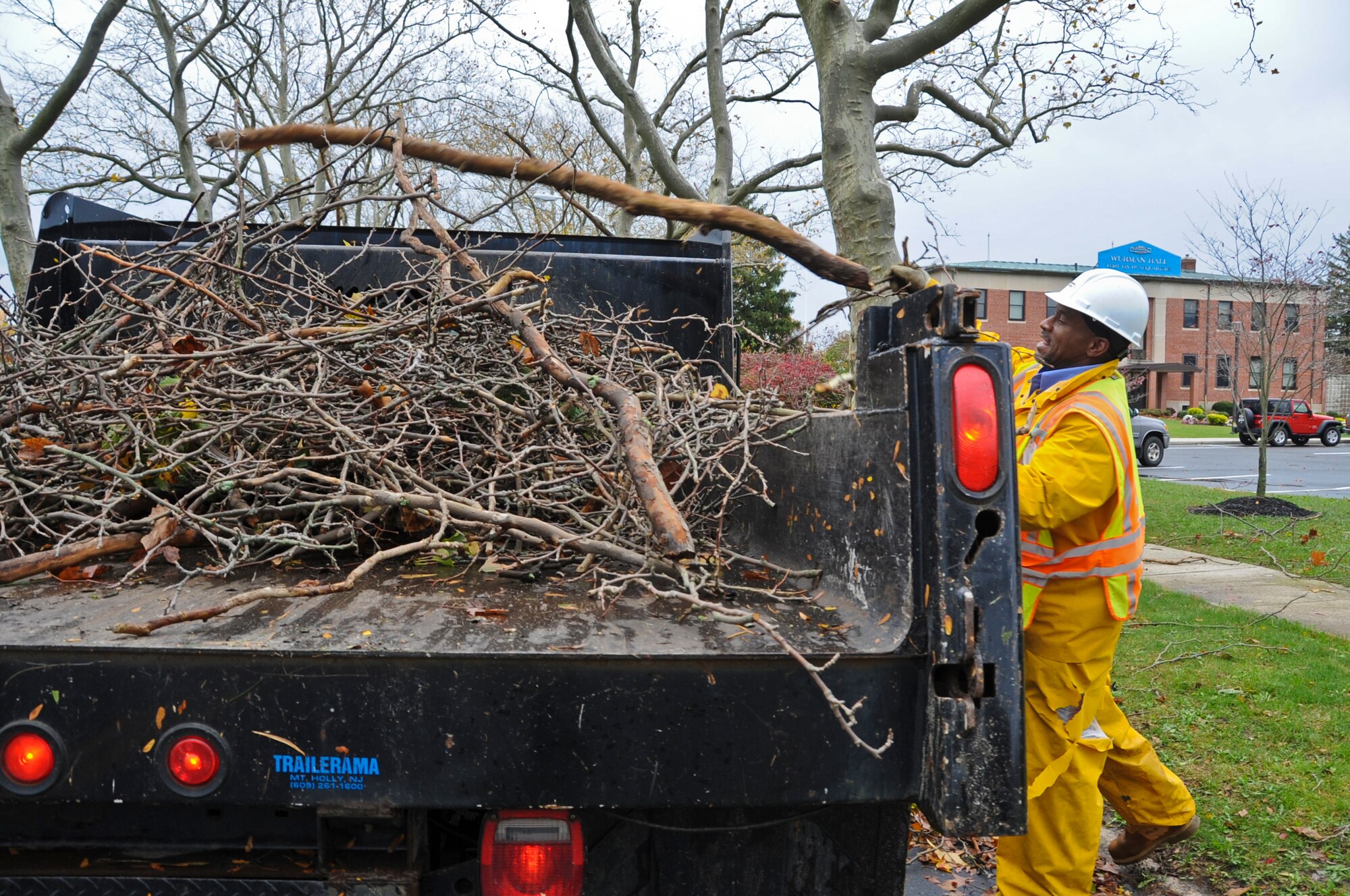 JOINT BASE MCGUIRE-DIX-LAKEHURST, N.J. -- Thomas Wills, contractor with Pride Industries, throws a tree limb into a brush truck near Wurman Hall on Dix Oct. 30, 2012. Several units from the joint base are supporting recovery operations following the damage caused by Hurricane Sandy which struck the base Oct. 29.  Several inches of rain, combined with powerful winds, caused power outages in various base housing areas and unit facilities. (U.S. Air Force photo by Staff Sgt. David Carbajal/Released)