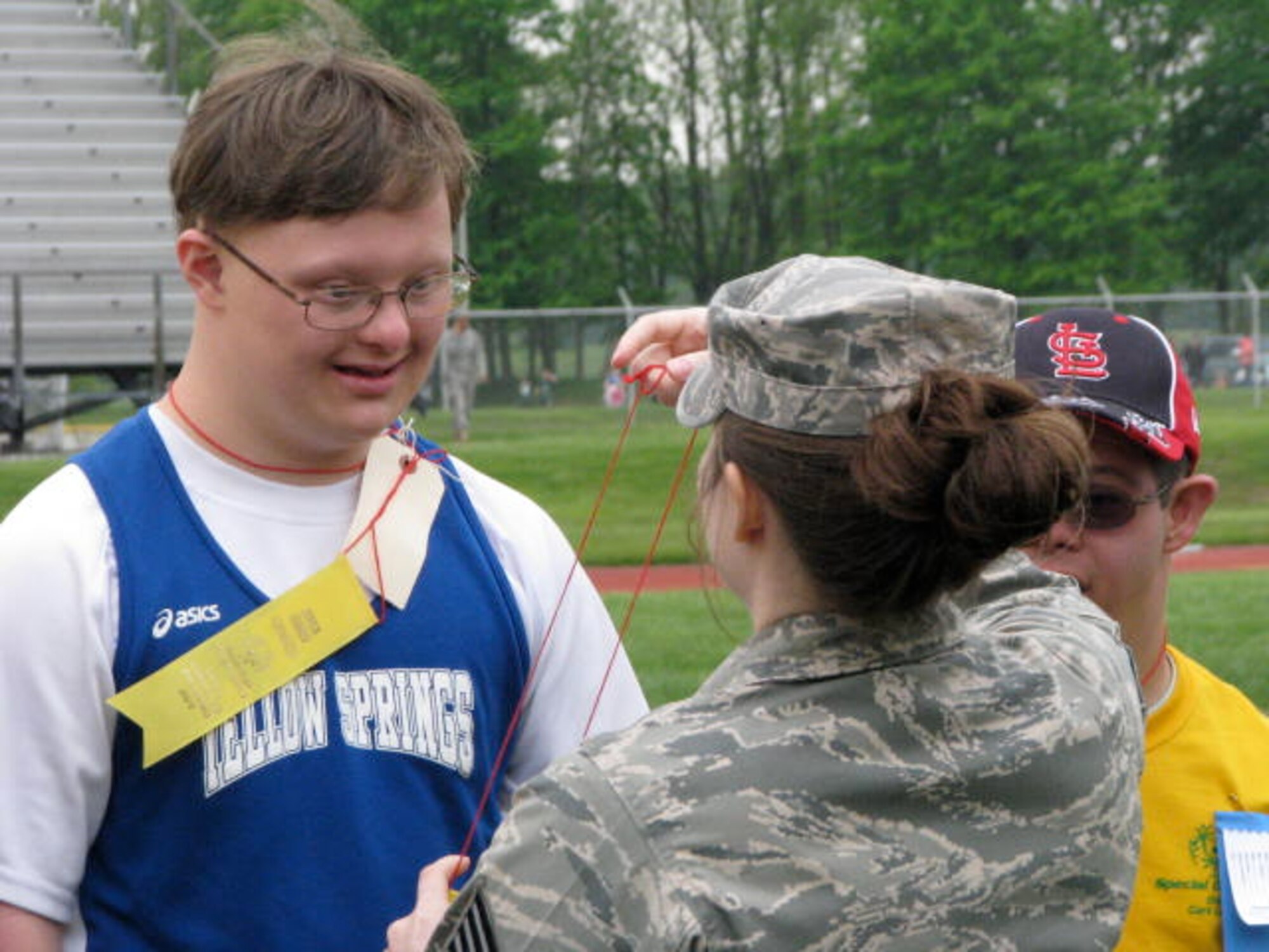Charlie, son of Col. George Fenimore, receives a ribbon from a noncommissioned officer from Wright-Patterson Air Force Base, Ohio, during the Special Olympics June 14, 2011 at Central State University, Wilberforce, Ohio. (Courtesy photo) 