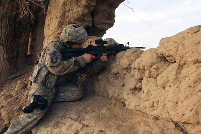 BADGHIS, Afghanistan -- U.S. Air Force Tech. Sgt. Kevin Wallace, Regional Command-West Media Combat Team photojournalist, pulls security after clearing a set of ruins in southern Bala Murghab Valley, near Combat Outpost Delorean, Bala Murghab, Badghis Province, Afghanistan Jan. 9, 2011. Wallace's team came under accurate small-arms fire while on a reconnaissance foot patrol in the area. (U.S. Navy photo/Mass Communications Specialist 1st Class John Pearl/RELEASED)