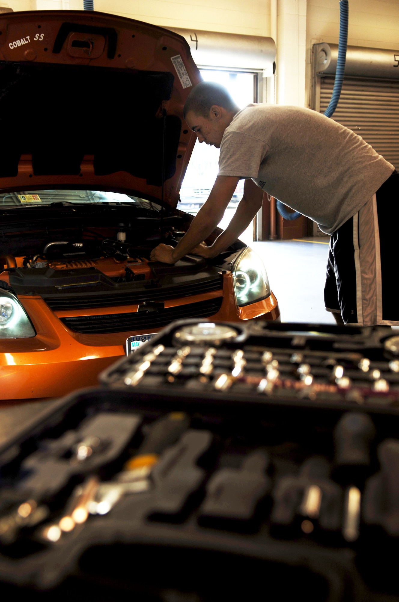 Airman 1st Class Deshar Cornelius, 1st Maintenance Squadron low observable aircraft maintenance apprentice, works on his car at the Auto Skills Center Oct. 25, 2012 at Langley Air Force Base, Va.  The Auto Skills Center offers a 24-bay complex equipped for do-it-yourself projects, and mechanics available for assistance.  (U.S. Air Force photo by Staff Sgt. Katie G. Ward / Released)