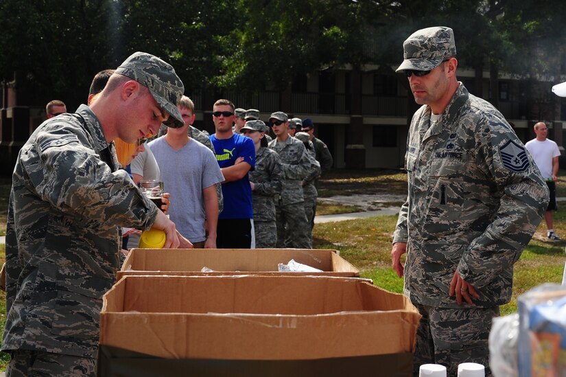 Airmen stand in line to get food at the 2012 Oktoberfest Oct. 26 at Joint Base Charleston - Air Base, S.C. 2012. Oktoberfest is an annual event put together by the First Six for ranks E-1 through E-6 to show appreciation for their day-to-day hard work. The event included free food and drinks, a disc jockey and a hot wing eating contest. Airmen also played games such as basketball and corn hole.