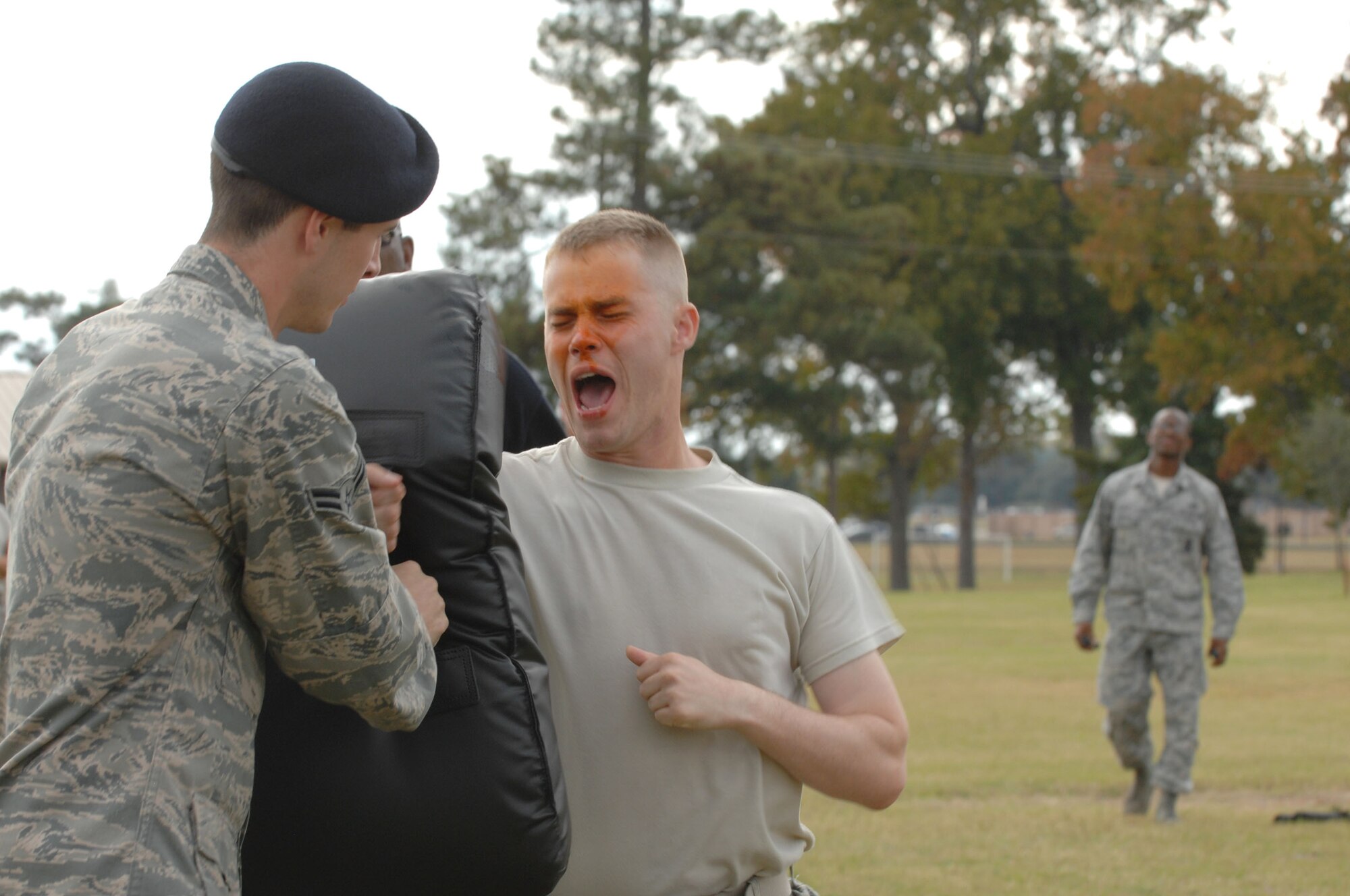 U.S. Air Force Airman 1st Class Erik Buckland holds a training pad while Airman 1st Class, Samuel Garr, both 20th Security Forces Squadron security response members,  practices attacking an enemy during an oleoresin capsicum pepper spray exercise.  First term security forces Airmen must complete this training after arriving at their first duty station. (U.S. Air Force photo by Airman Nicole Sikorski/Released)