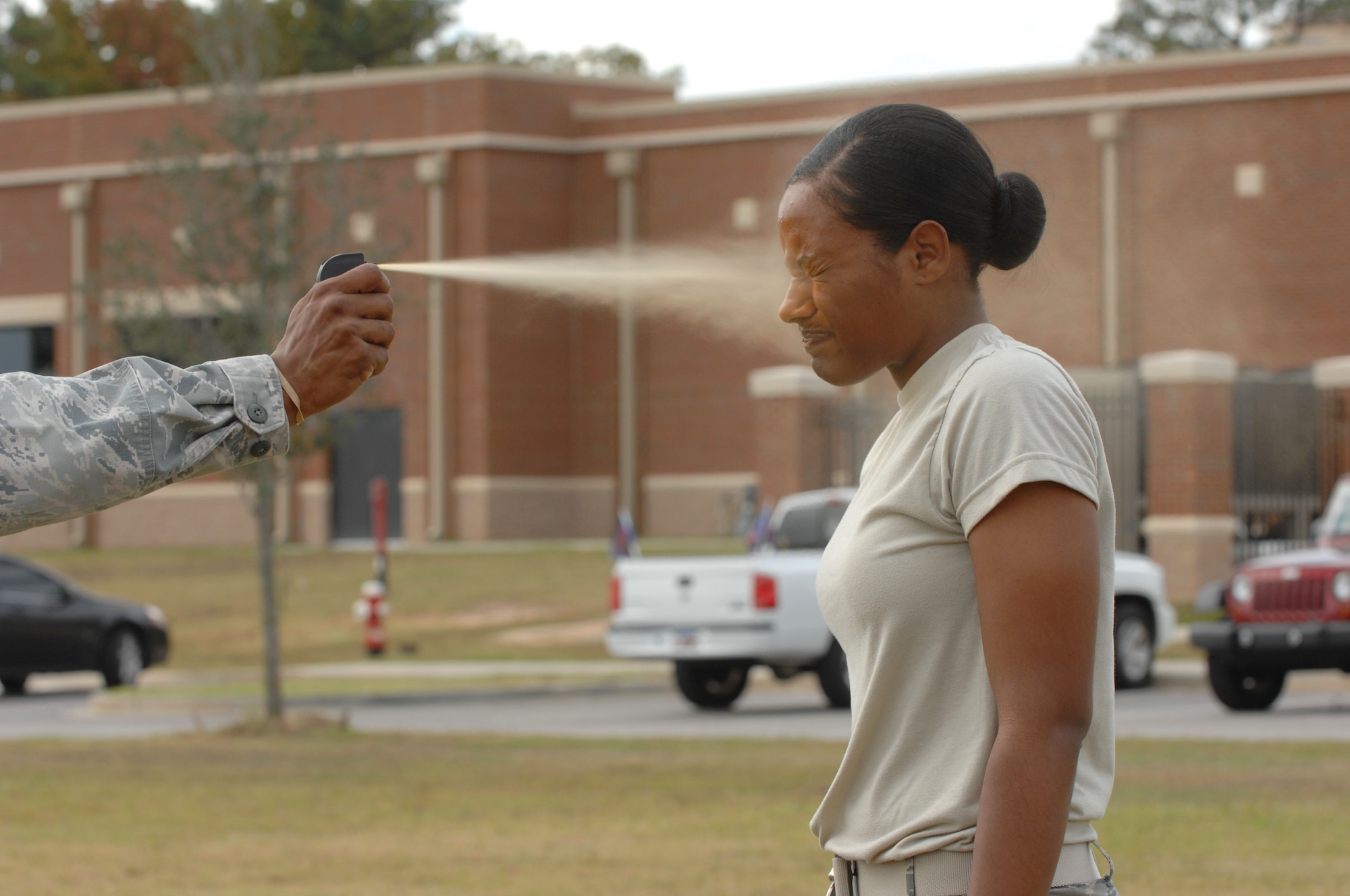 U.S. Air Force Airman Janessa Bottoms, 20th Security Forces Squadron security response member, stands at attention while being sprayed with oleoresin capsicum pepper spray.  First term security forces Airmen must complete this training after arriving at their first duty station.  After being pepper sprayed, they complete different obstacles which challenge them to chase an enemy while disoriented. (U.S. Air Force photo by Airman Nicole Sikorski/Released)