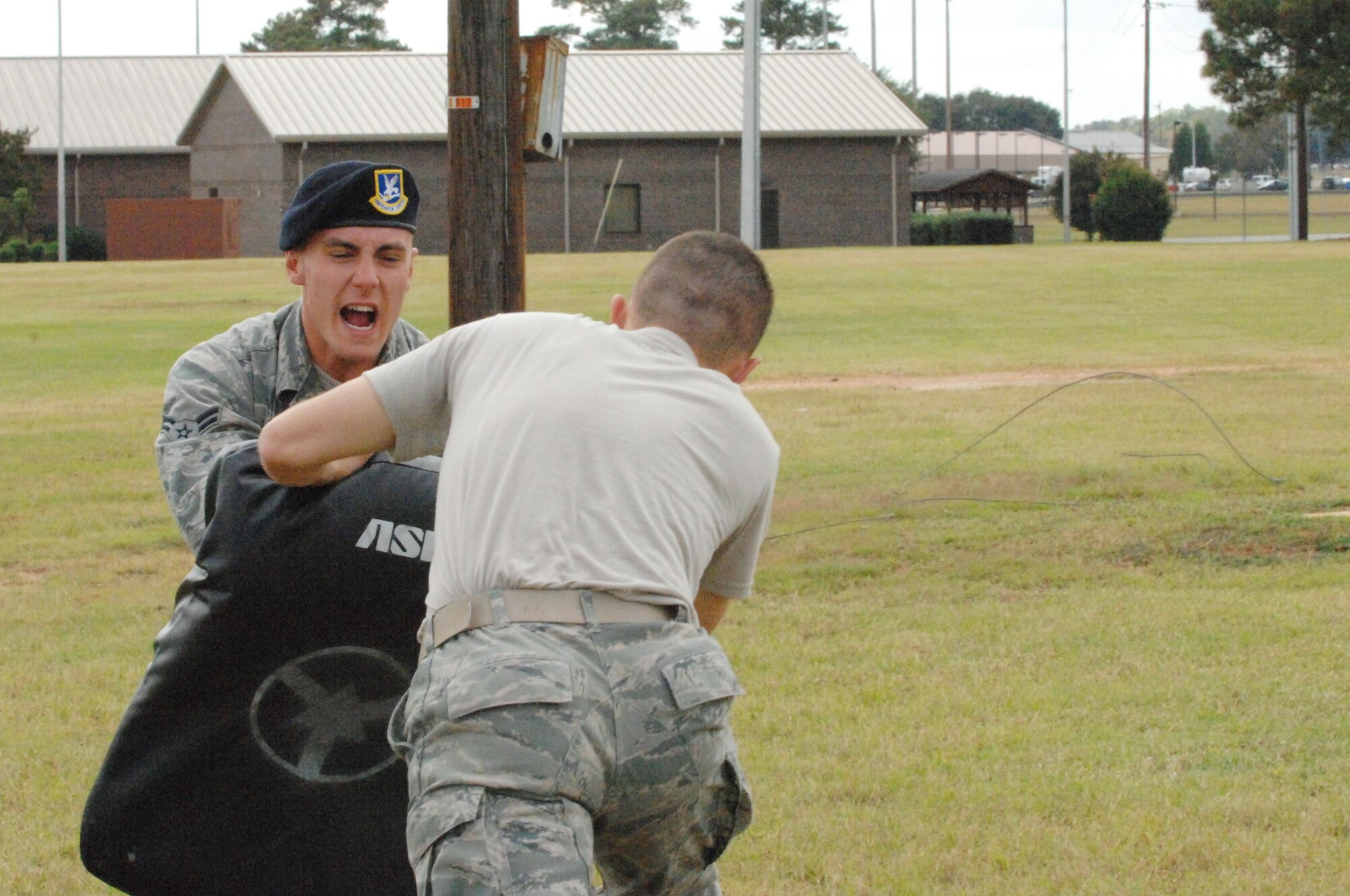 U.S. Air Force Airman 1st Class Jacob Buckley holds a training pad as Airman 1st Class Robert Graves, both 20th Security Forces Squadron security response members practices attacking an enemy after being exposed to oleoresin capsicum pepper spray.  First term security forces Airmen must complete this training after arriving at their first duty station. (U.S. Air Force photo by Airman Nicole Sikorski/Released)