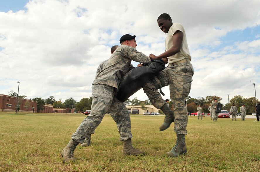 U.S. Air Force Airman 1st Class Jacob Buckley holds a training pad as Airman James Patterson, both 20th Security Forces Squadron security response members, practices attacking an enemy after being exposed to oleoresin capsicum pepper spray.  First term security forces Airmen must complete this training after arriving at their first duty station. (U.S. Air Force photo by Airman Nicole Sikorski/Released)