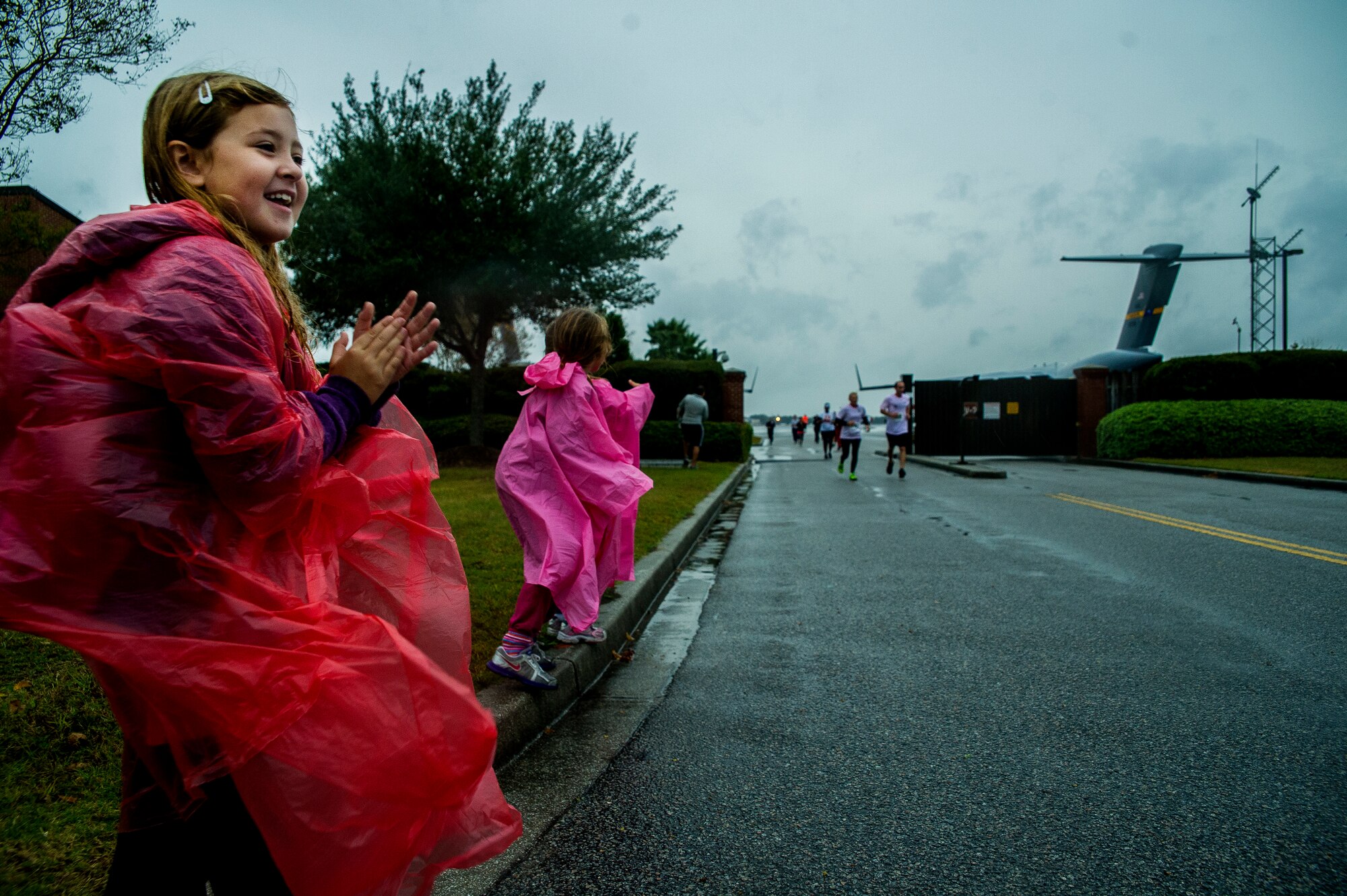 Kinsley Bordeaux, daughter of Master Sgt. Harold Bordeaux, 16th Airlift Squadron loadmaster superintendent, directs runners during the fourth annual Run the Runway 5K event honoring retired Brig. Gen. Thomas Mikolajcik Oct. 27, 2012, at Joint Base Charleston - Air Base, S.C. The 437th Airlift Wing hosted the event which was open to all military, Department of Defense civilians and the local community. (U.S. Air Force photo/ Airman 1st Class George Goslin)
