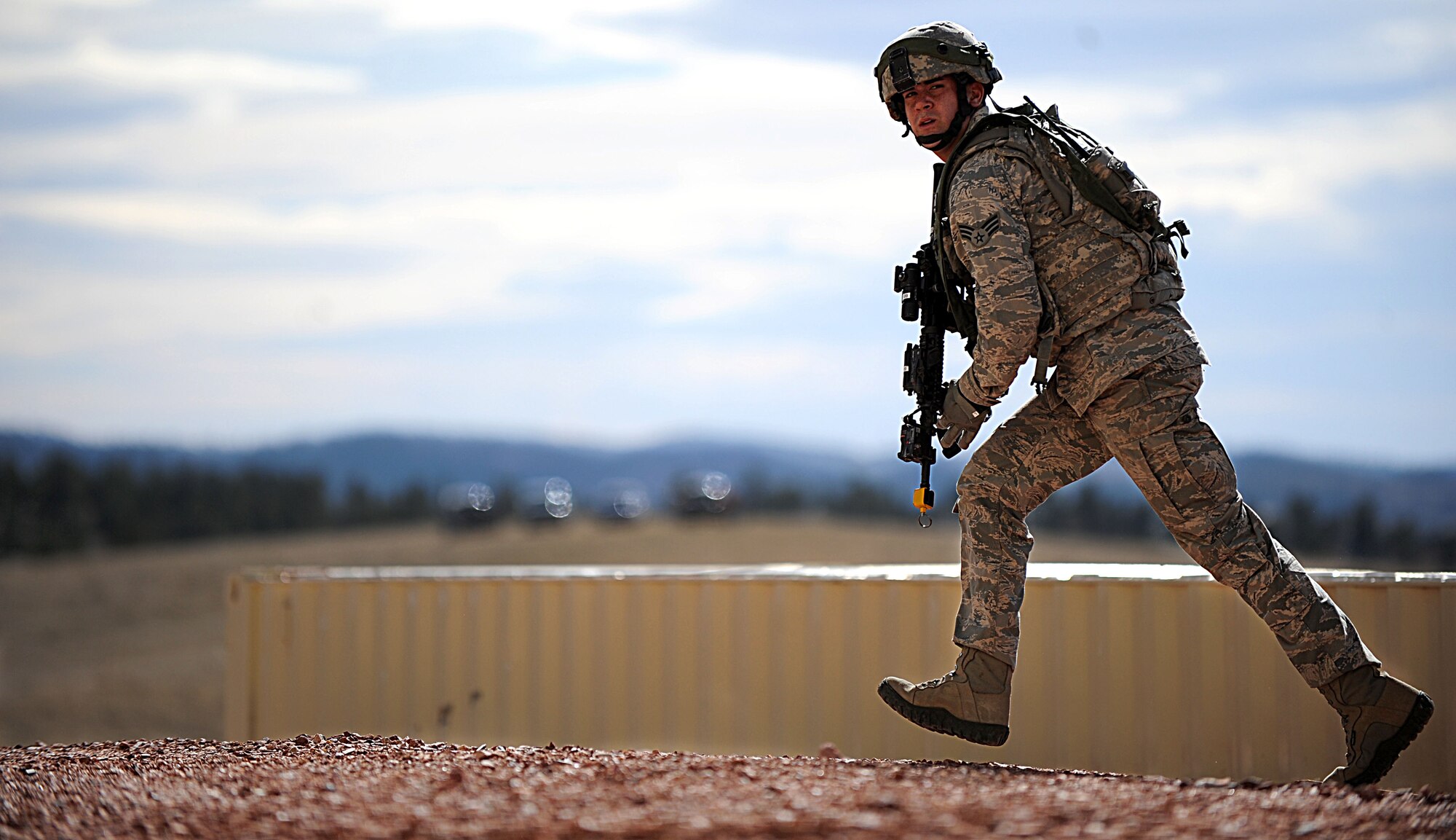A Security Forces airman from F.E. Warren Air Force Base, Wyo. moves to a more secure position during the Road Warrior exercise at Camp Guernsey, Wyo., Oct. 20, 2012. The Airmen participating in this exercise were trained on the tactics necessary to transport, safeguard and recover a nuclear resource. (U.S. Air Force photo by Senior Airman Jarad A. Denton/Released)