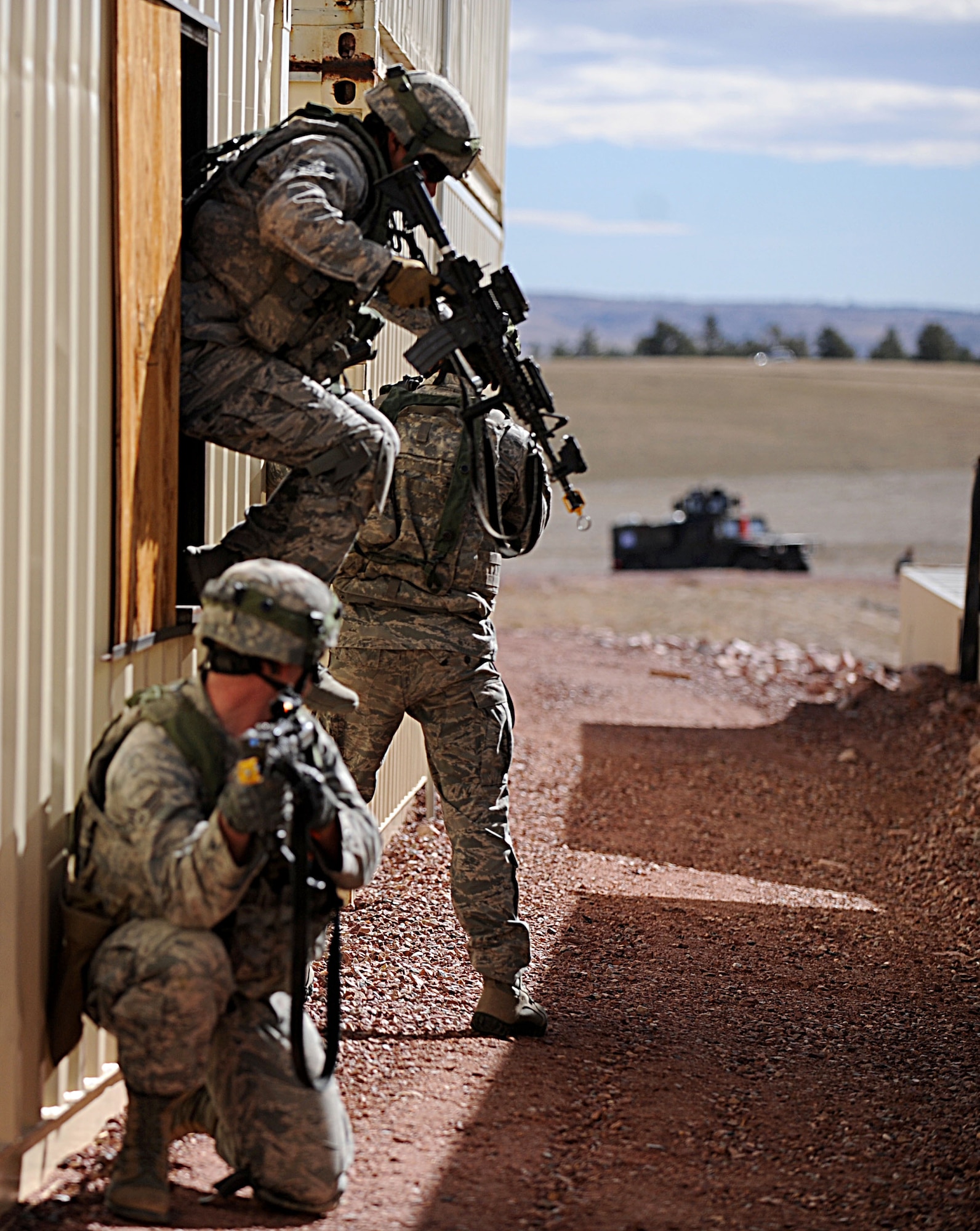 A Security Forces airman from F.E. Warren Air Force Base, Wyo. jumps out a window while two other Airmen secure the area during the Road Warrior exercise at Camp Guernsey, Wyo., Oct. 20, 2012. The Airmen who attended the training were charged with the task of transporting, safeguarding and recovering a nuclear resource while under threat from an opposing force. (U.S. Air Force photo by Senior Airman Jarad A. Denton/Released)