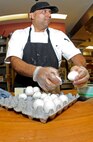Baker Jessie Torres cracks eggs to use for baking a batch of cookies, Oct. 30 at the David Grant Medical Center dining facility. (U.S. Air Force photo/ Staff Sgt. Liliana Moreno)