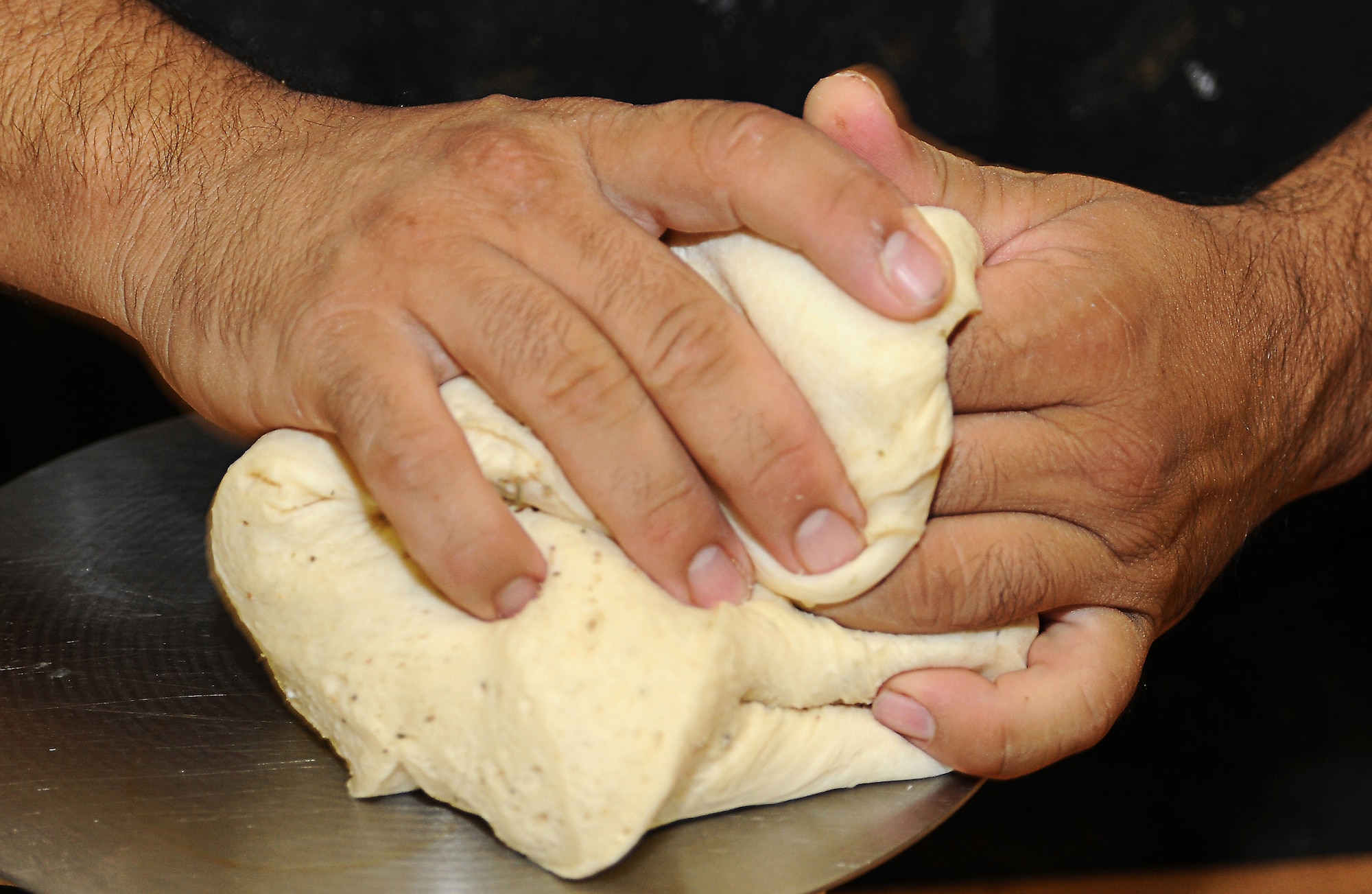 Baker Jessie Torres kneads dough to make bread loafs, Oct. 30 at the David Grant Medical Center dining facility. (U.S. Air Force photo/ Staff Sgt. Liliana Moreno)
