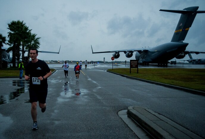 Participants run between a pair of C-17s during the fourth annual Run the Runway 5K event honoring retired Brig. Gen. Thomas Mikolajcik Oct. 27, 2012, at Joint Base Charleston - Air Base, S.C. The 437th Airlift Wing hosted the event which was open to all military, Department of Defense civilians and the local community. (U.S. Air Force photo/ Airman 1st Class George Goslin) 
