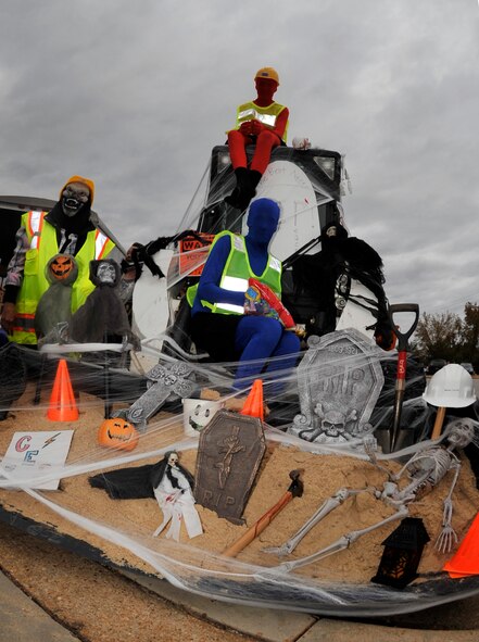 Liao Walter (blue suit) and Tallon Hannus (red suit) pass out candy aboard the 20th Civil Engineer Squadron's decorated construction bobcat, Shaw Air Force Base, S.C. Oct. 12, 2012. 20th CES won the "trunk-or-treat" contest in which monsters and Halloween trimmings were used to decorate vehicles. (U.S. Air Force photo by Airman Basic Neil D. Warner/Released)