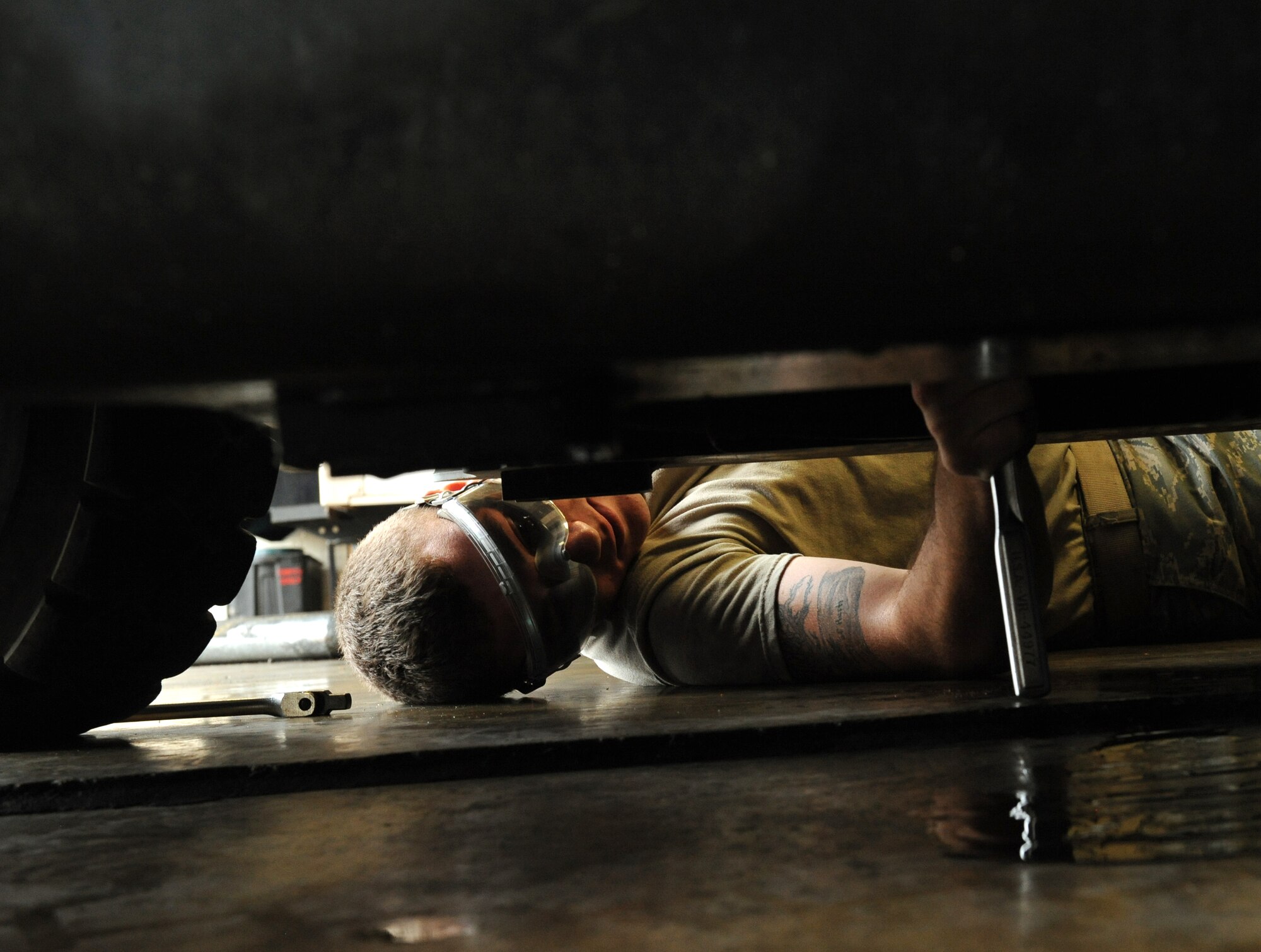 Airman 1st Class Cody Akers, 2nd Logistics Readiness Squadron Vehicle Maintenance lube rack technician, tightens an oil drain plug underneath a vehicle on Barksdale Air Force Base, La., Oct. 24. Lube rack technicians perform oil changes, filter changes and inspect the vehicles' fluid systems. (U.S. Air Force photo/Airman 1st Class Benjamin Gonsier)(RELEASED)


