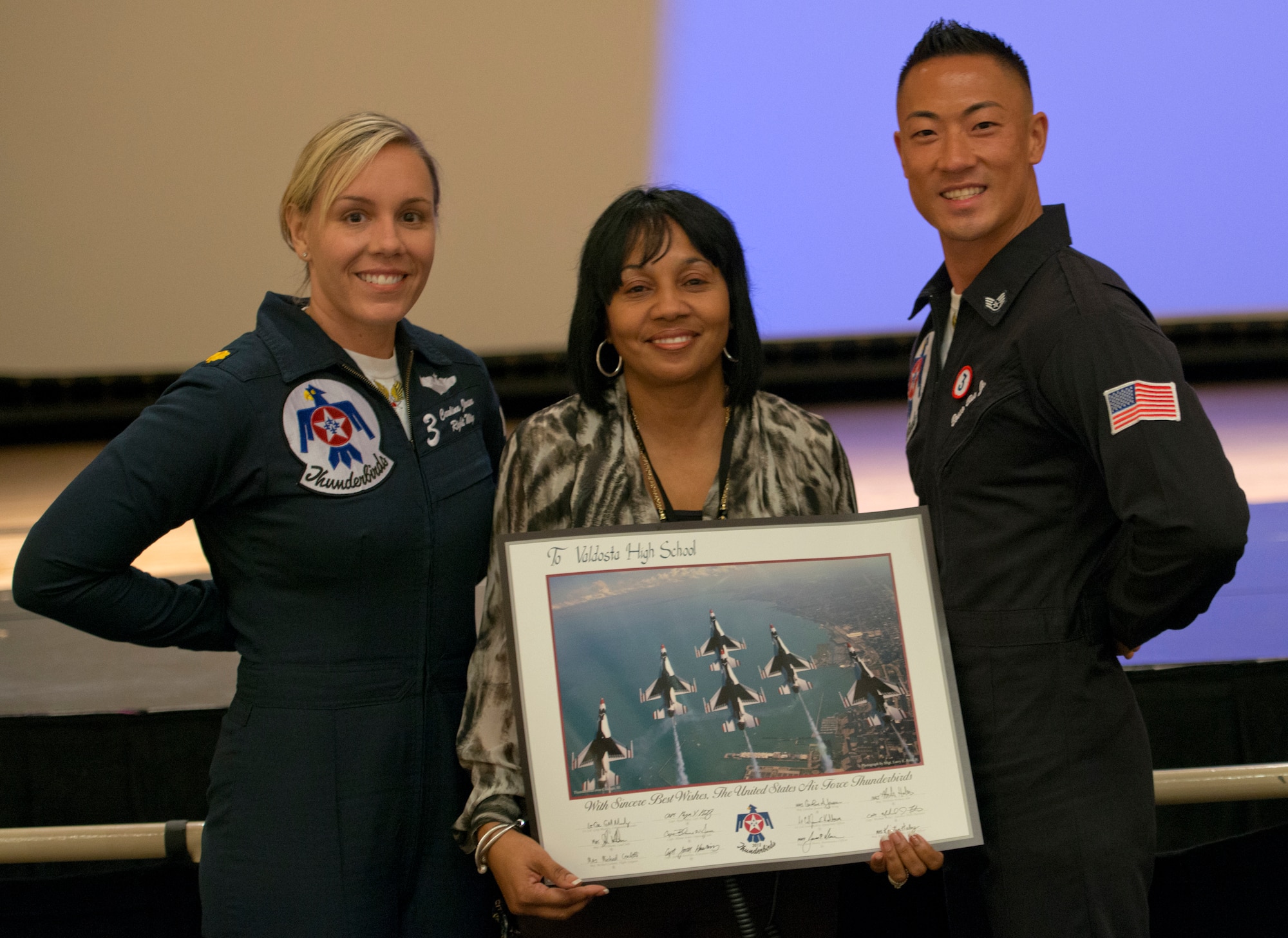 Maj. Caroline Jensen, U.S. Air Force Thunderbird 3 right wing pilot, and Staff Sgt. Bosco Bae, Thunderbirds tactical aircraft maintenance craftsman, present Dr. Janice Richardson, Valdosta High School principle, with an autographed photo at Valdosta High School, Ga., Oct. 26, 2012.  Jensen and Bae also talked with students about their careers in the Air Force. (U.S. Air Force photo by Senior Airman Douglas Ellis/Released) 
