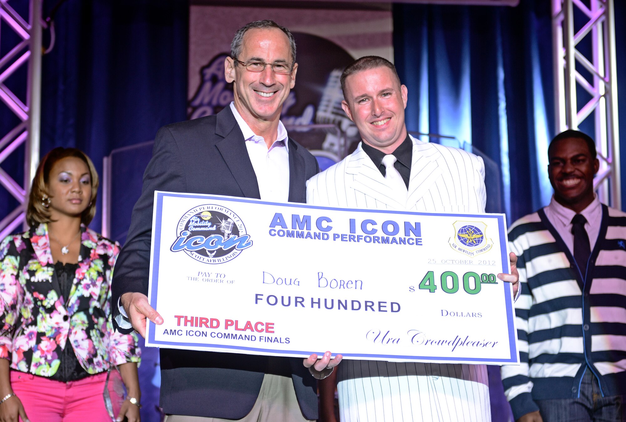 Tech. Sgt. Doug Boren, from McConnell Air Force Base, accepts his third place award after performing for a crowd of more than 200 at the Scott Air Force Base club Oct. 25, 2012. Ten performers participated in the 2012 AMC Icon, a contest similar to the famed American Idol in which contestants competed for cash prizes and a spot to perform in the U.S. Air Force Tops in Blue group. 1Lt. Nicole White took the top prize with Staff Sgt. Tiry Crane as the runner up and TSgt Doug Boren in third place. (U.S. Air Force photo/ Staff Sgt. Ryan Crane)