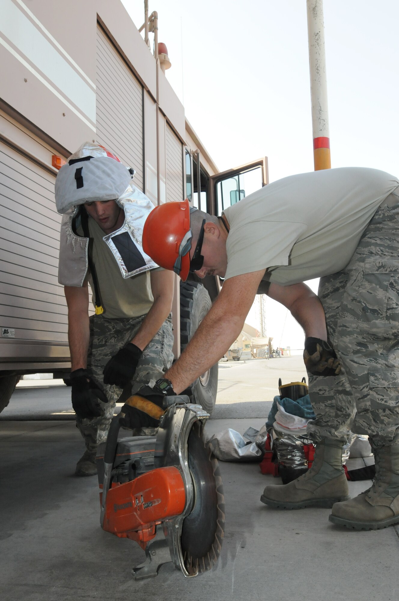 SOUTHWEST ASIA - U.S. Air Force Airman 1st Class Nathaniel Grim and Staff Sgt. Jeffrey Price, 380th Expeditionary Civil Engineer Squadron Fire Department Station 1 firefighters, operations check a rescue saw Oct. 29, 2012. The 380th ECES fire department trains constantly to ensure all firefighters are proficient and meeting mandated requirements. (U.S. Air Force photo/Tech. Sgt. Amanda Savannah)