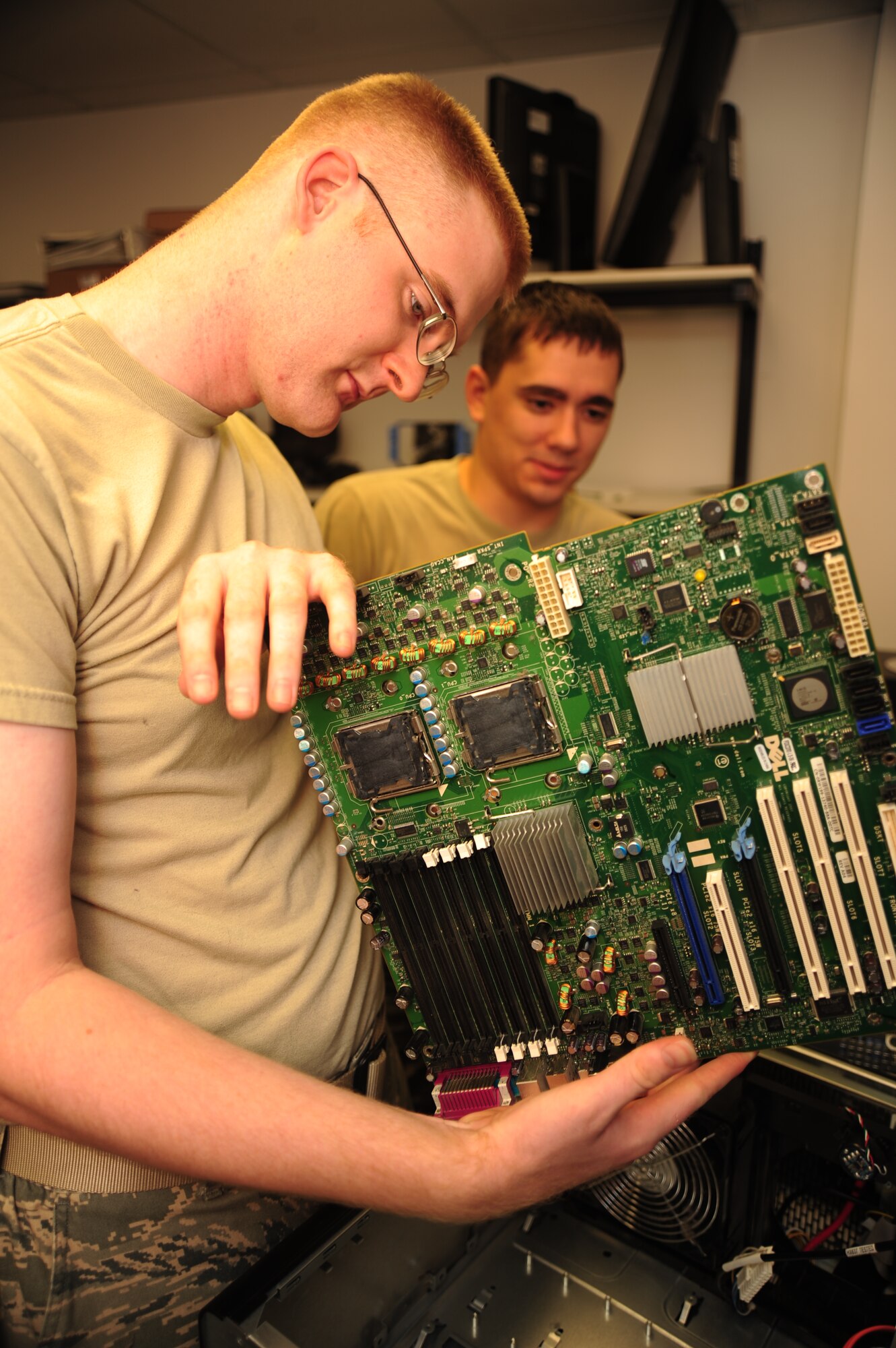 WHITEMAN AIR FORCE BASE, Mo. -- Staff Sgt. Justin Guyor, 509th Communications Focal point assistant NCOIC, inspects a desktop computer’s motherboard for defects as Senior Airman Wesley Snider, 509th CS client services technician, observes. To ensure that crystal-clear or lightning-fast communication, drives the process to ensure that senior leaders' communications requirements are met and to track down the specialists needed to fix problems as they arise. (U.S. Air Force photo/Senior Airman Nick Wilson) (Released)