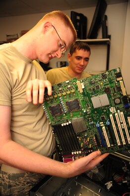 WHITEMAN AIR FORCE BASE, Mo. -- Staff Sgt. Justin Guyor, 509th Communications Focal point assistant NCOIC, inspects a desktop computer’s motherboard for defects as Senior Airman Wesley Snider, 509th CS client services technician, observes. To ensure that crystal-clear or lightning-fast communication, drives the process to ensure that senior leaders' communications requirements are met and to track down the specialists needed to fix problems as they arise. (U.S. Air Force photo/Senior Airman Nick Wilson) (Released)