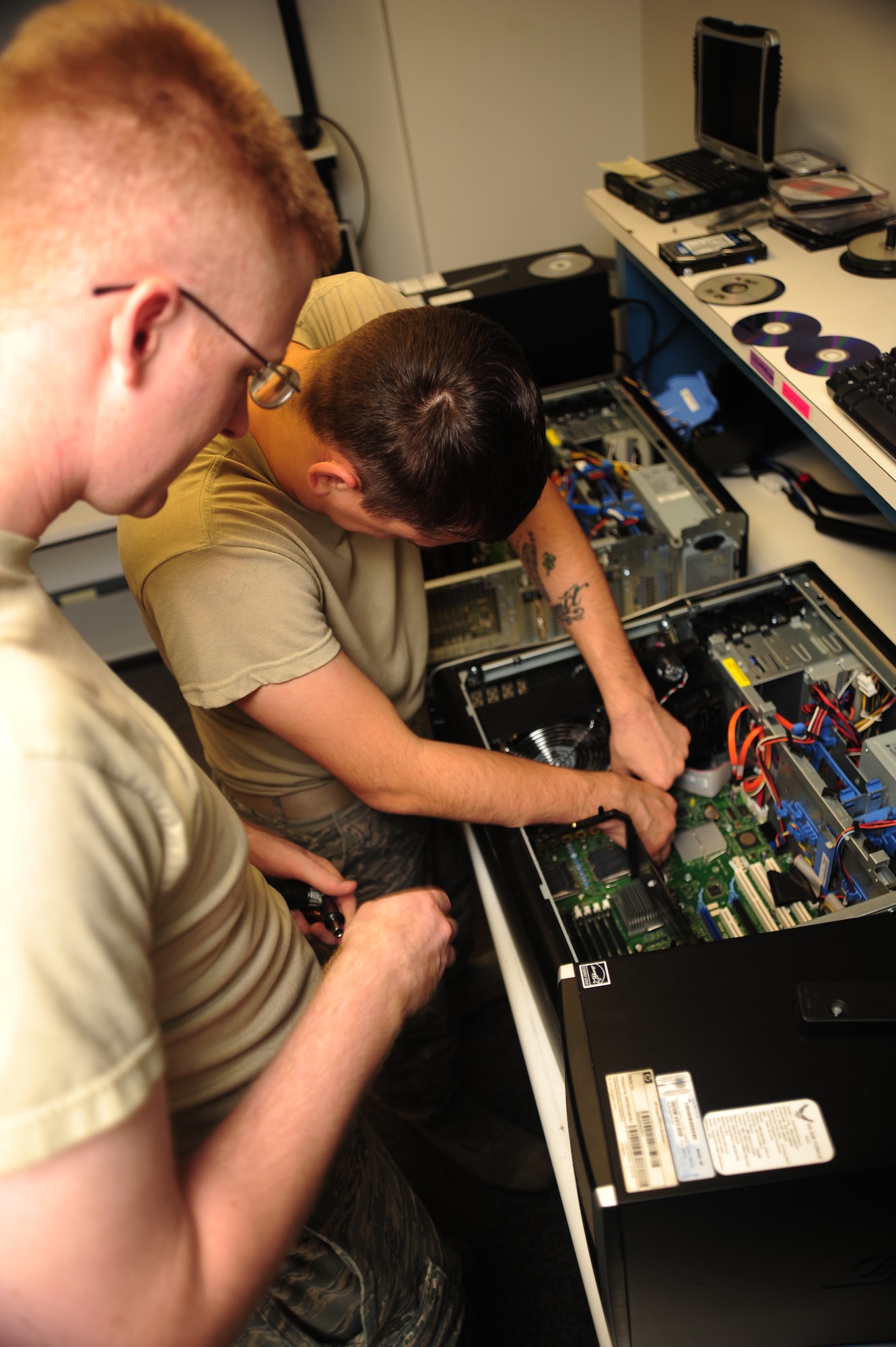 WHITEMAN AIR FORCE BASE, Mo. -- Staff Sgt. Justin Guyor, 509th Communications Focal point assistant NCOIC, supervises as Senior Airman Wesley Snider, 509th CS client services technician, disconnects a power cable from the mother board of a computer Sept. 6. Airmen from the Communications Support Section ensure base computer and communications networking systems are maintained -- providing specialists on site to quickly remedy challenges. (U.S. Air Force photo/Senior Airman Nick Wilson) (Released)