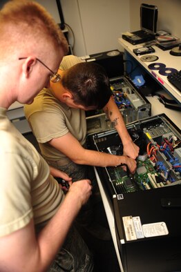 WHITEMAN AIR FORCE BASE, Mo. -- Staff Sgt. Justin Guyor, 509th Communications Focal point assistant NCOIC, supervises as Senior Airman Wesley Snider, 509th CS client services technician, disconnects a power cable from the mother board of a computer Sept. 6. Airmen from the Communications Support Section ensure base computer and communications networking systems are maintained -- providing specialists on site to quickly remedy challenges. (U.S. Air Force photo/Senior Airman Nick Wilson) (Released)